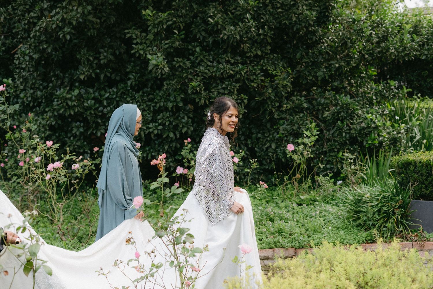 Couple celebrating their wedding day in a verdant garden setting with traditional cultural elements.