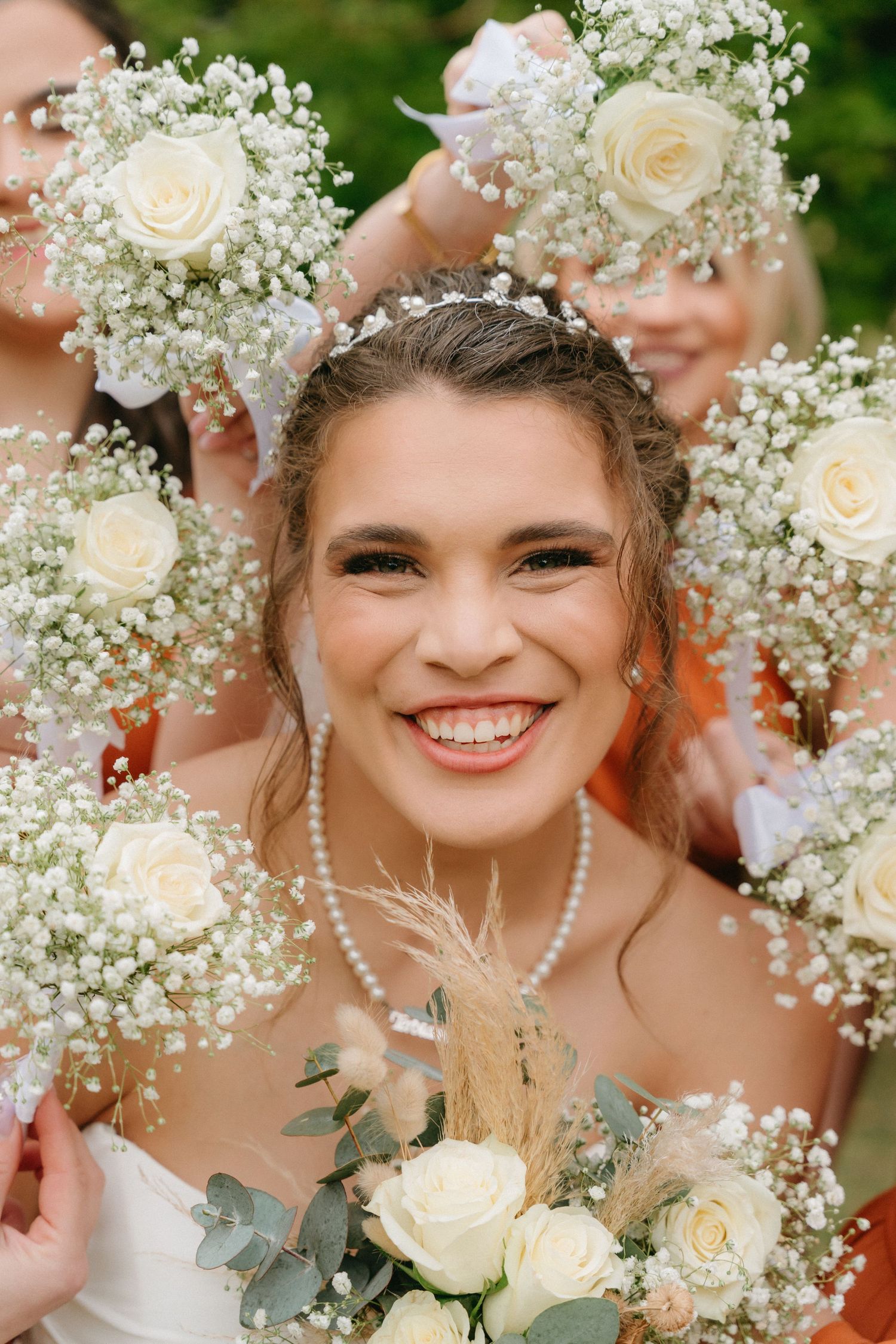 Delicate white roses and baby's breath bouquets frame a joyful wedding moment.
