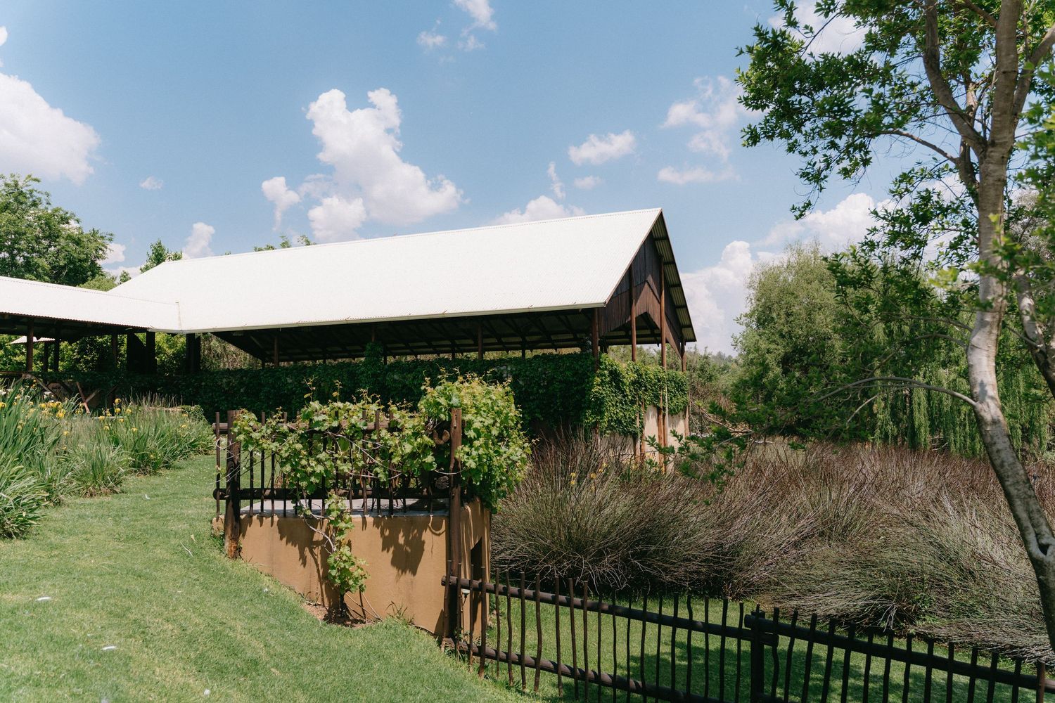 Panoramic view of a rustic outdoor wedding venue with rolling hills and blue sky.