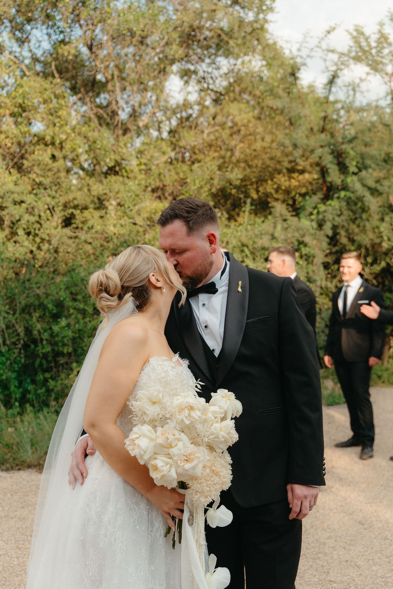 A romantic wedding moment captured in a series of photos showing a couple embracing outdoors with white floral bouquet.