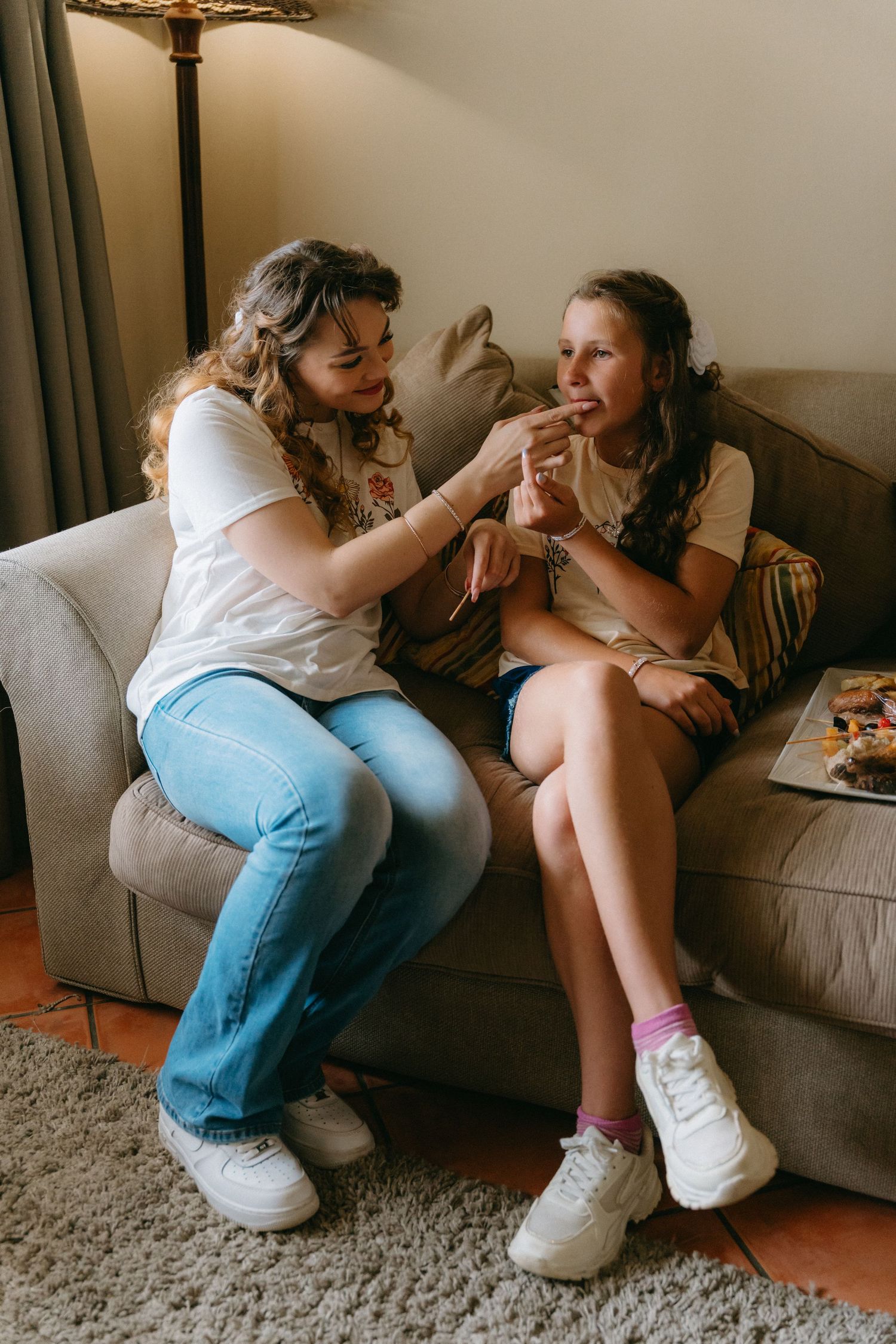 A sequence of candid moments showing two people sharing laughter and playful interactions on a gray couch.