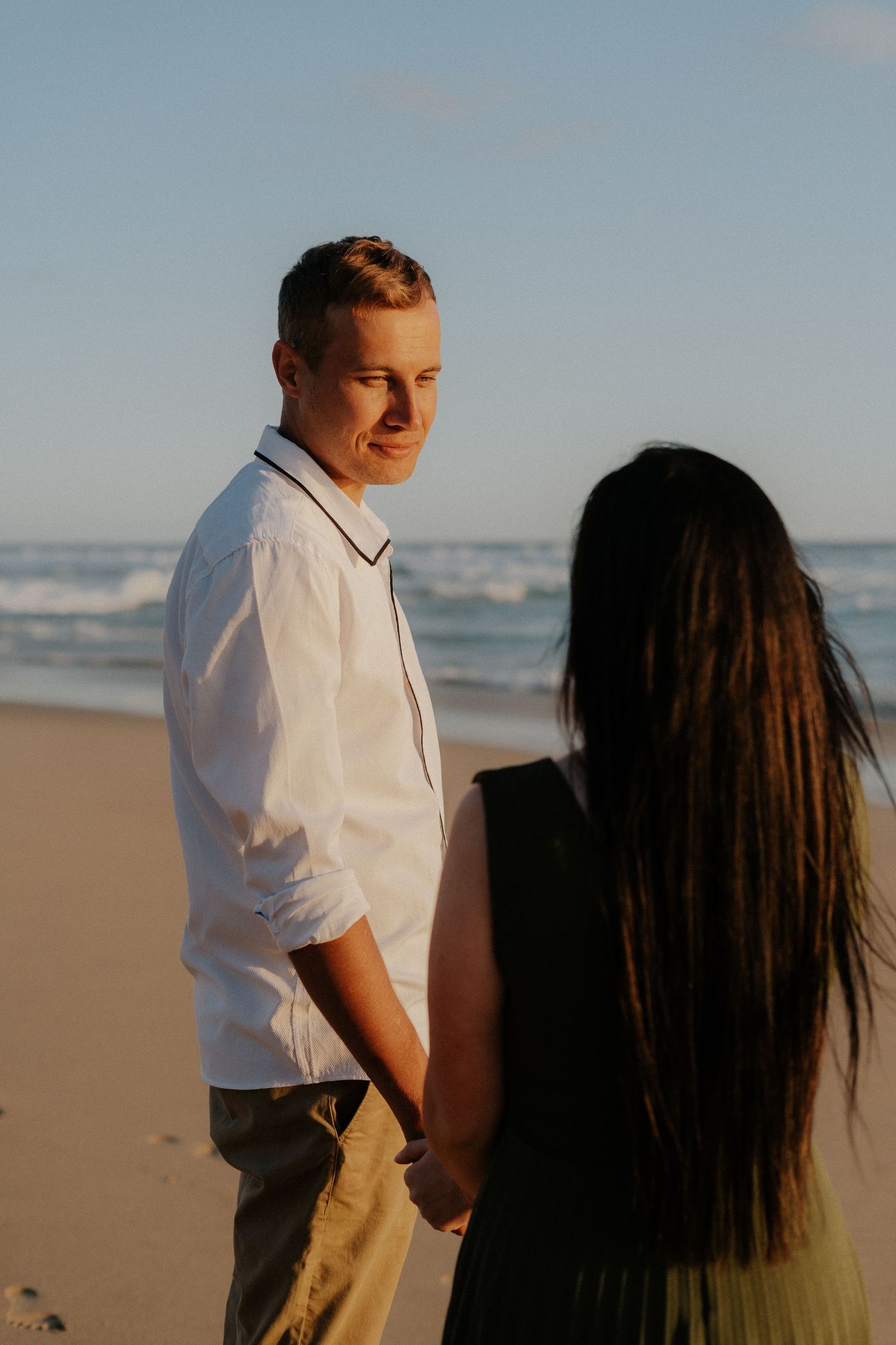 A couple walks along a scenic beach at sunset, in South Africa