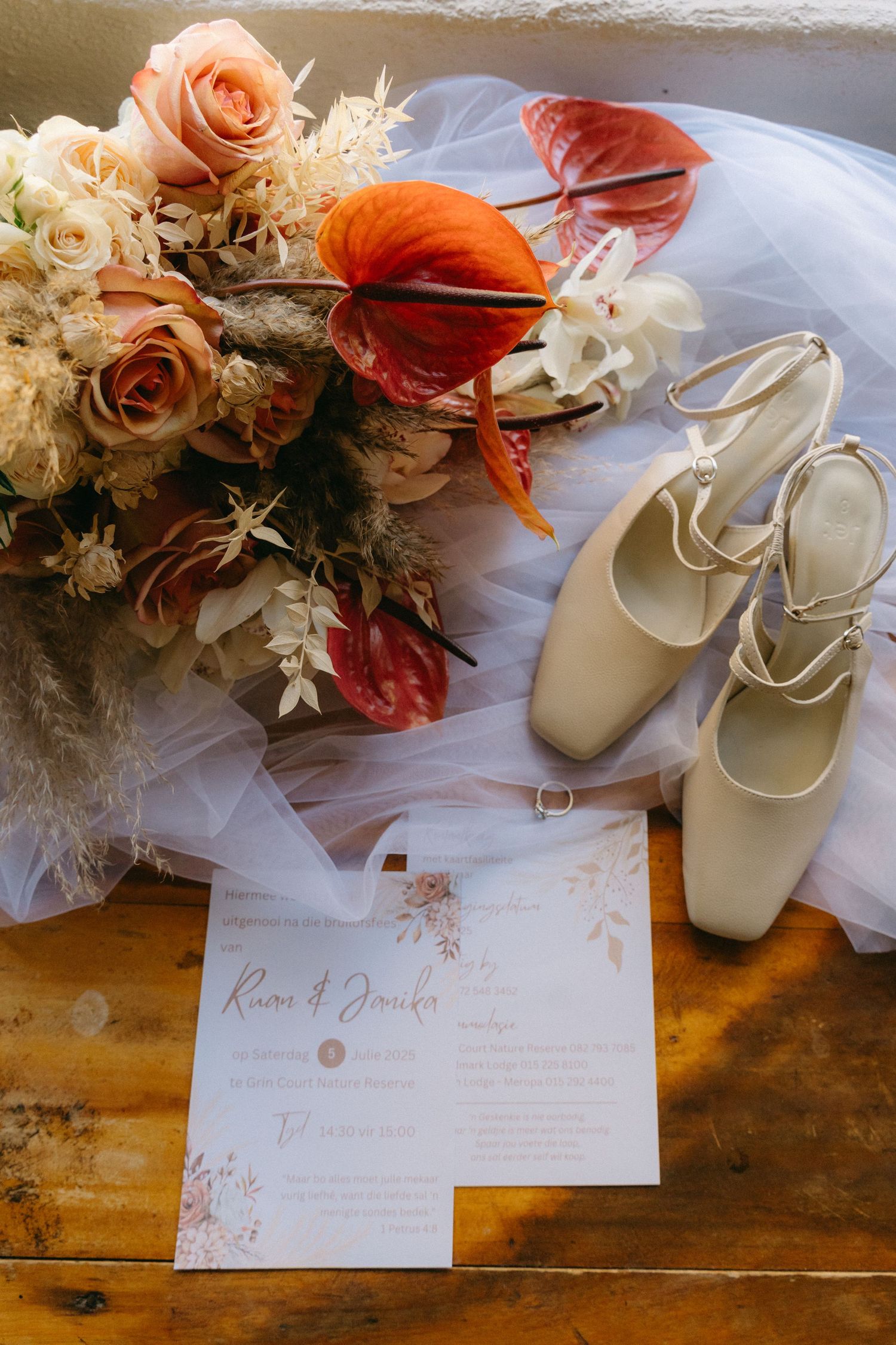 Wedding details including floral arrangements, white shoes, and handwritten notes on a wooden surface.