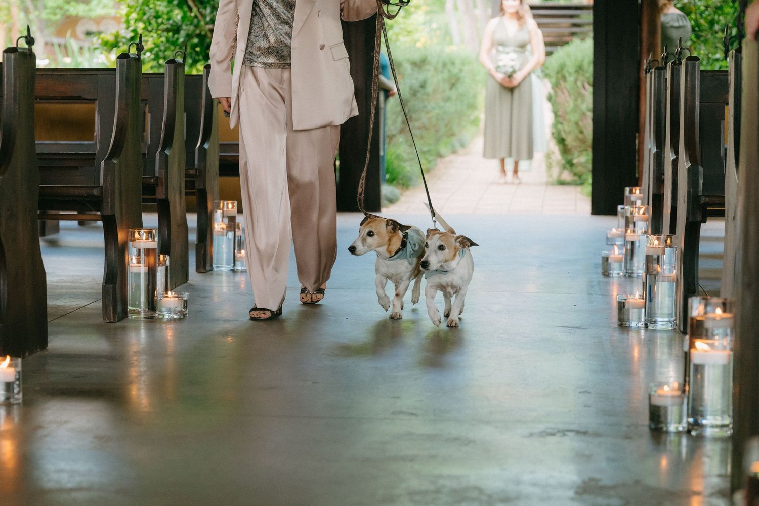 Wedding party members walking through covered outdoor venue walkway.