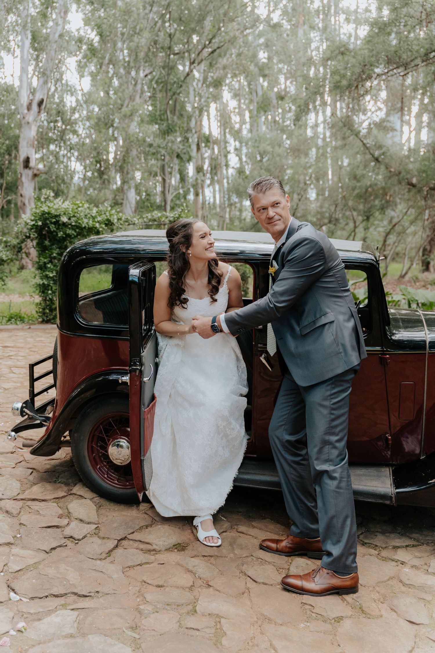 A wedding couple poses with a vintage car on stone pavement in a sequence of romantic candid moments.