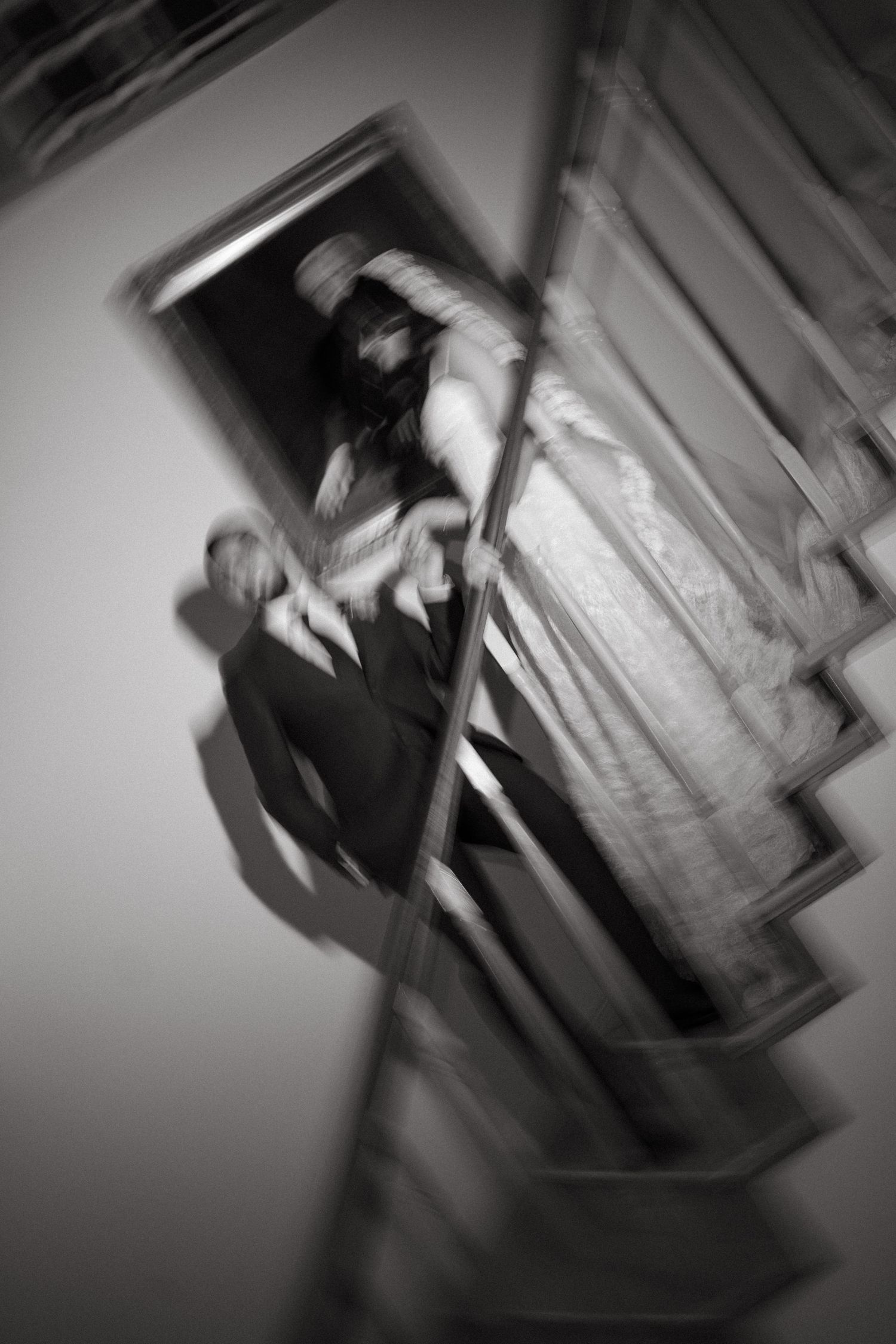 Artistic blurred black and white photo of bride and groom on staircase in Beechwood Gardens with motion effect.