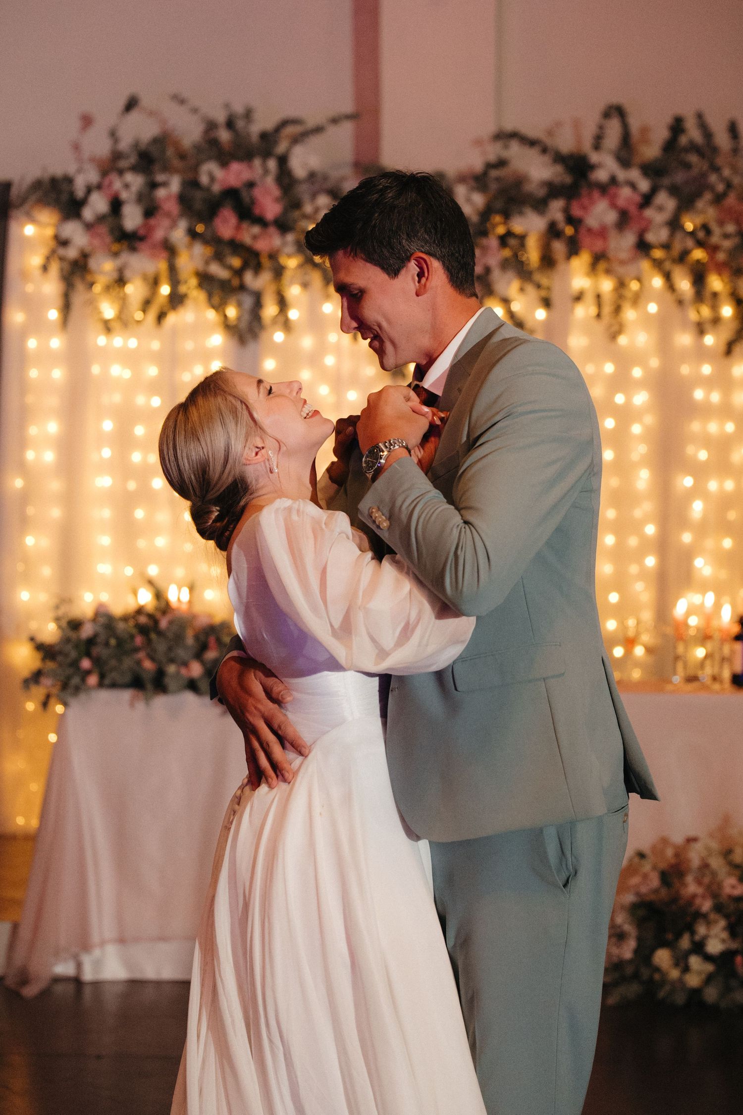 Bride and groom sharing first dance before glowing fairy light backdrop in Rustenburg, South Africa