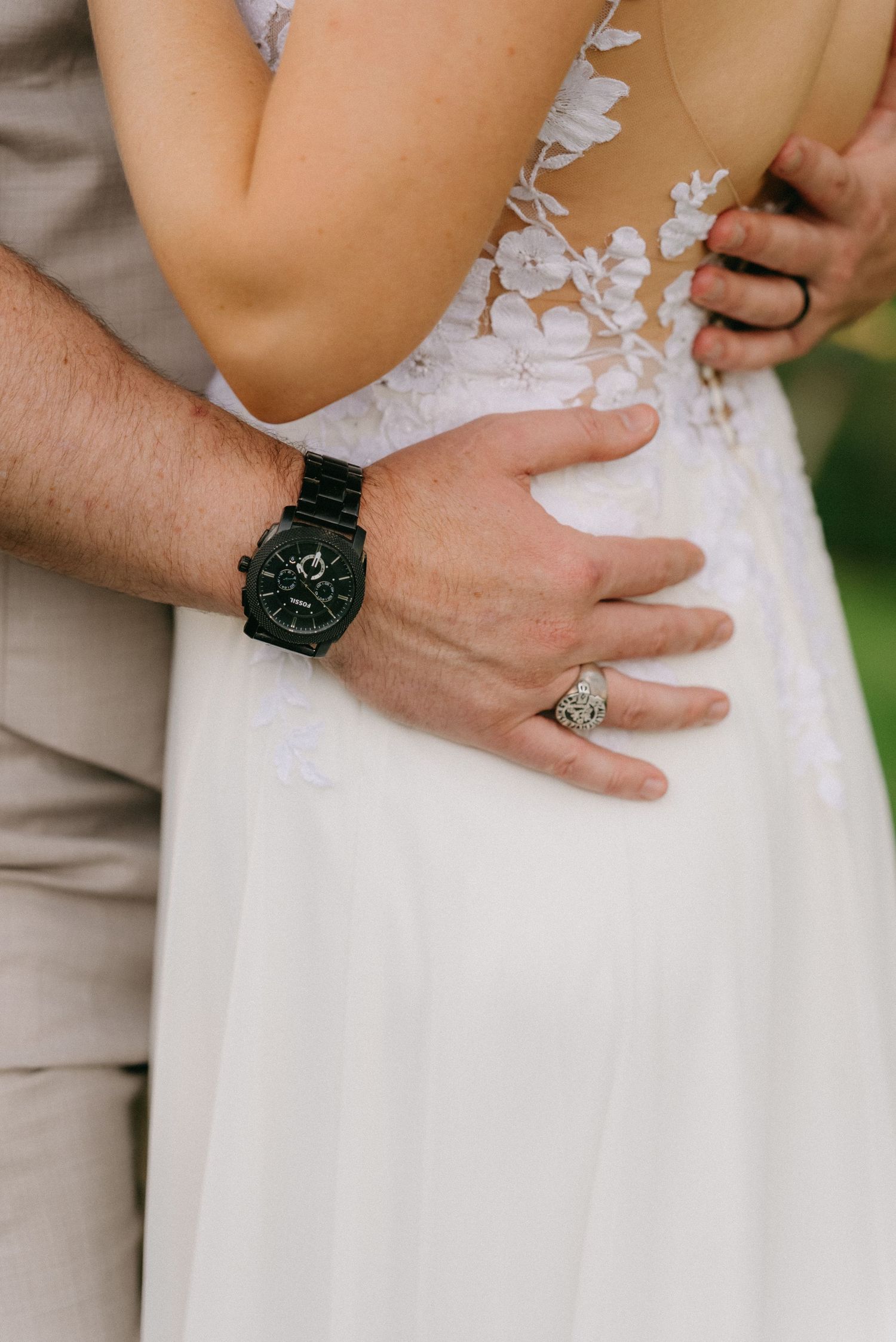 Close-up details of hands and wedding dress lace with elegant watches.