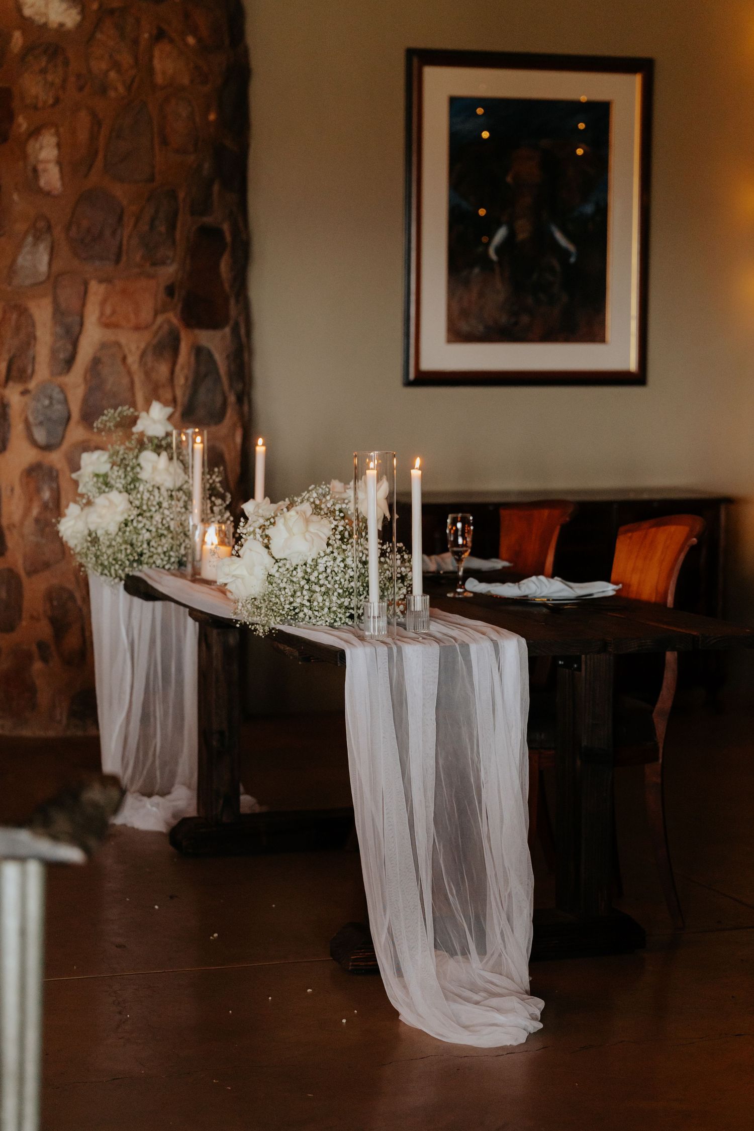 Elegant table settings with white candles and draped fabric for wedding reception.