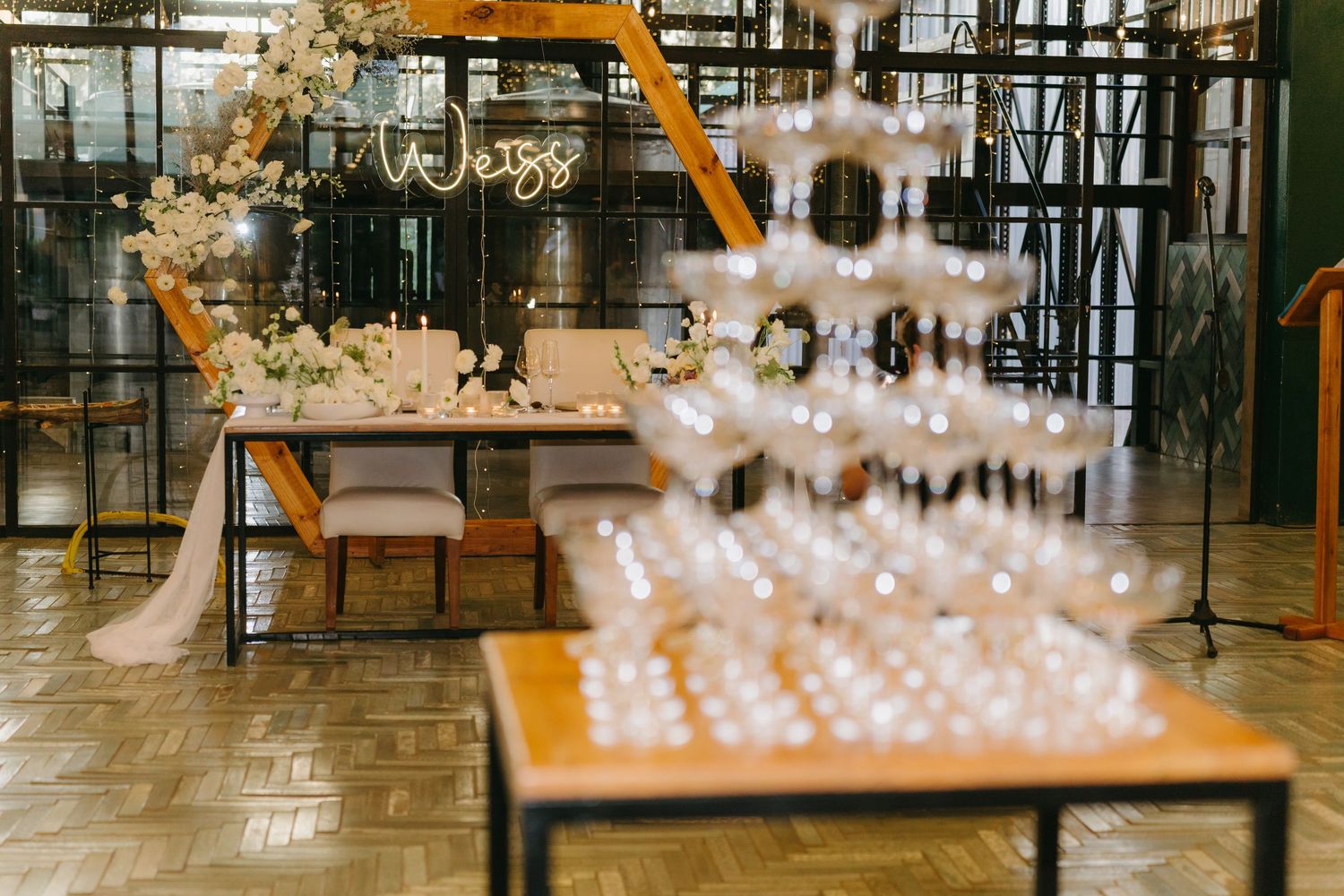 An elegant wedding reception setup with champagne tower and warm lighting details.