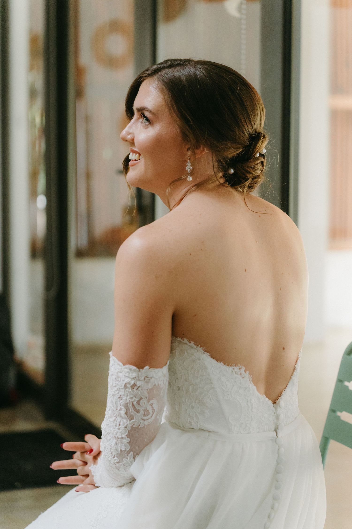 Bride in strapless wedding gown smiling during candid moment.