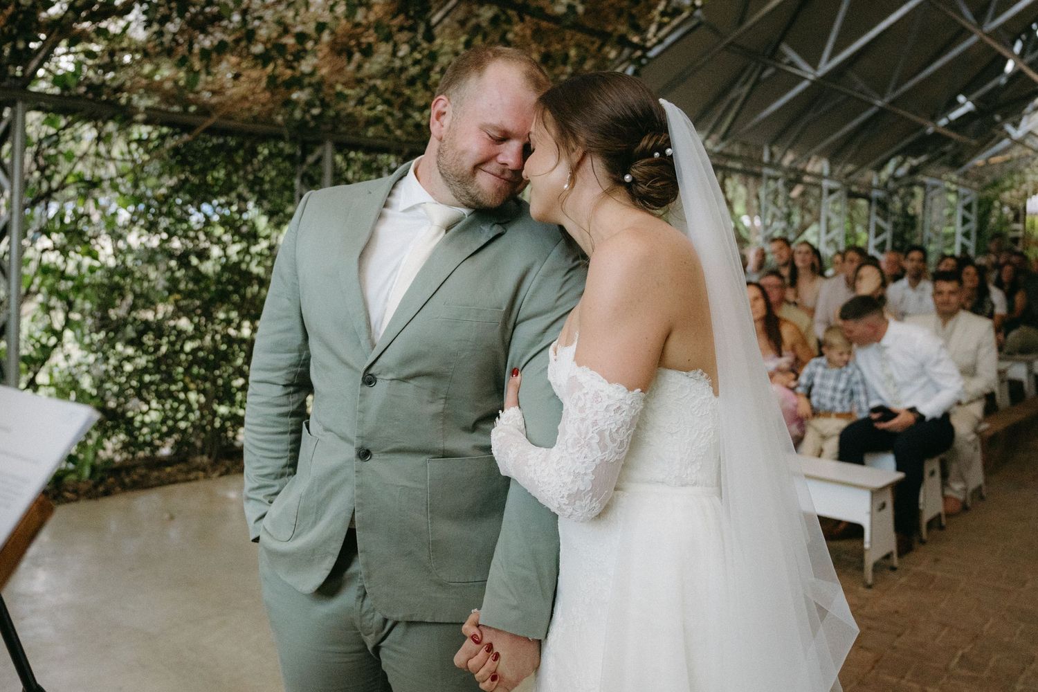 A sweet intimate moment shared between newlyweds during their outdoor wedding ceremony.
