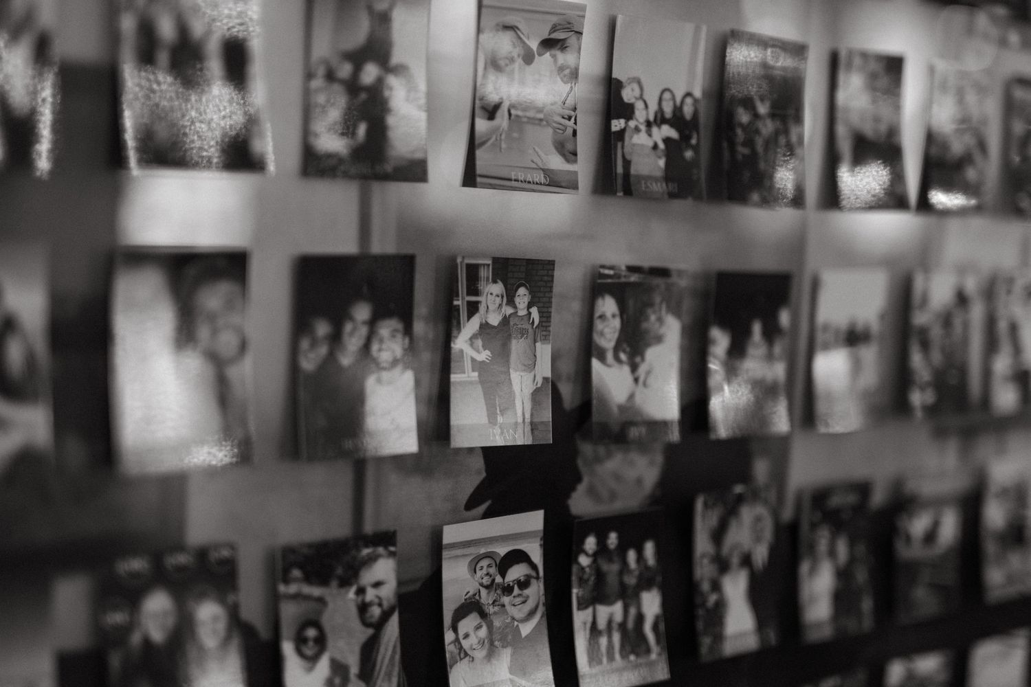 Wall display of vintage black and white photographs in a gallery setting.