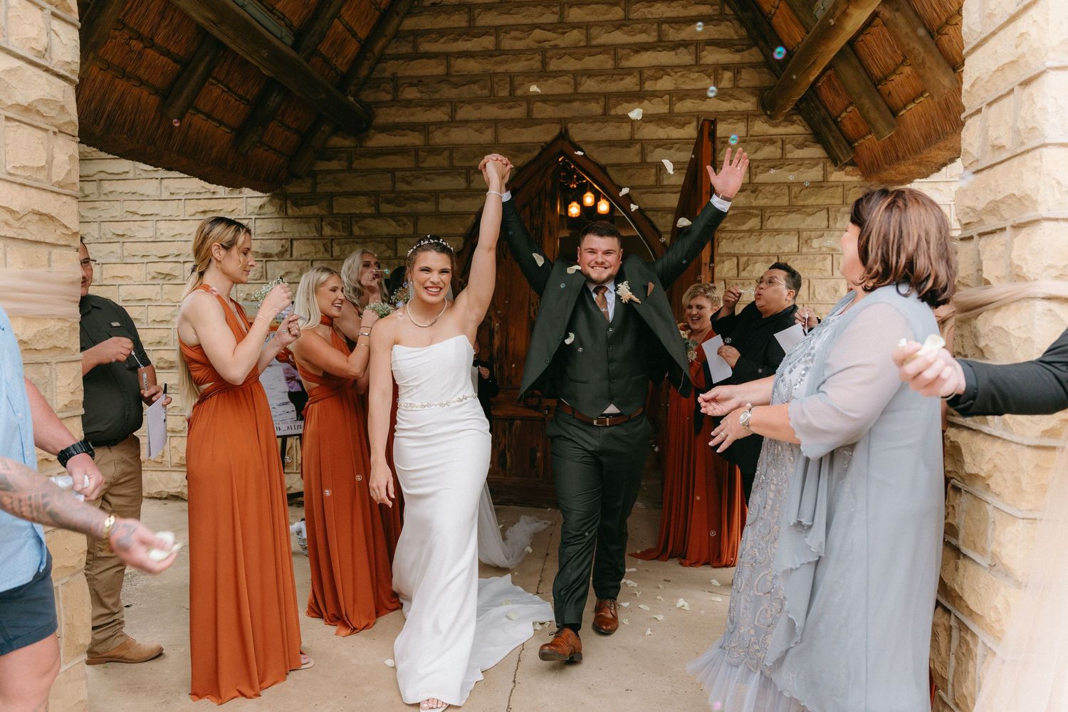 Wedding celebration inside stone building with rustic wooden beams.