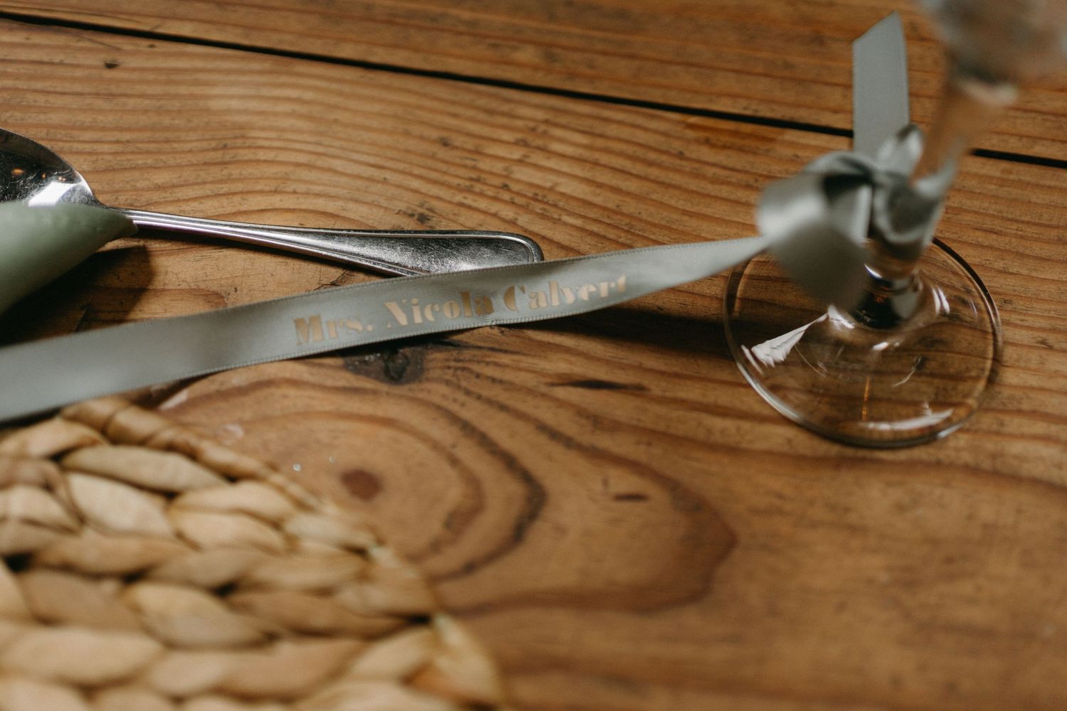 Vintage metal compass and protractor tools rest on a weathered wooden surface with visible wood grain patterns.
