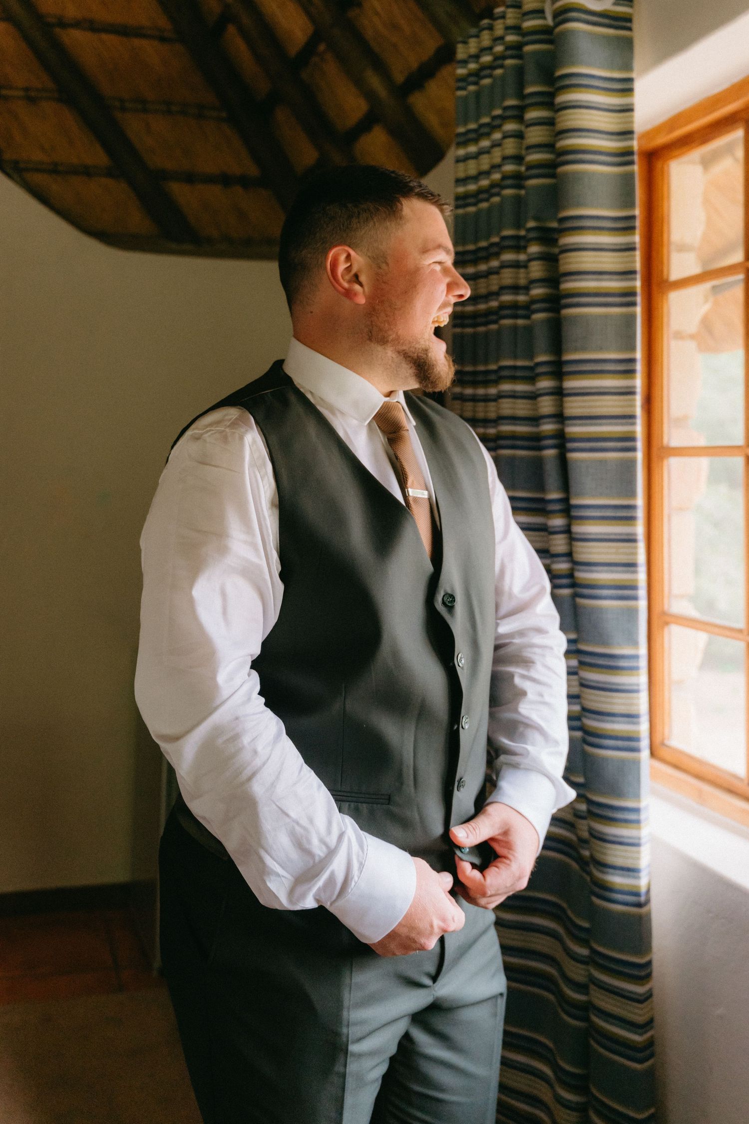 Formal attire preparation showing dark vest and white shirt near window light.