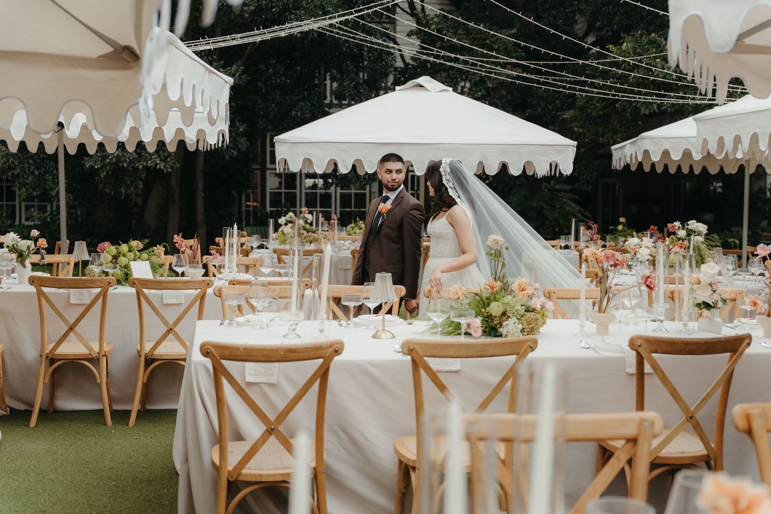 Bride and groom standing in elegantly decorated outdoor wedding reception at Beechwood Gardens