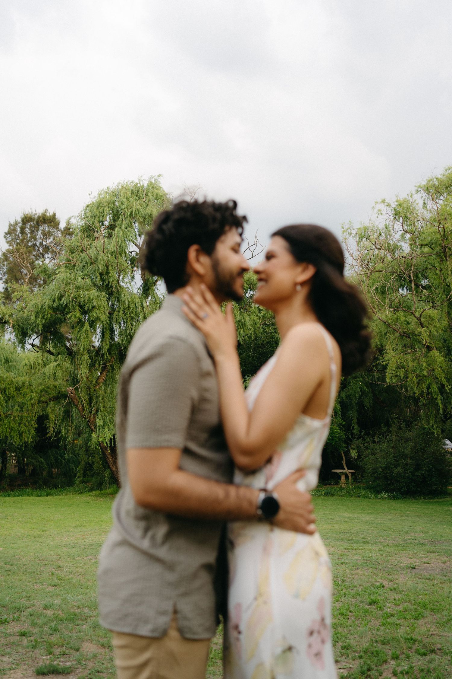 An intimate moment shared between two people in a green outdoor setting.