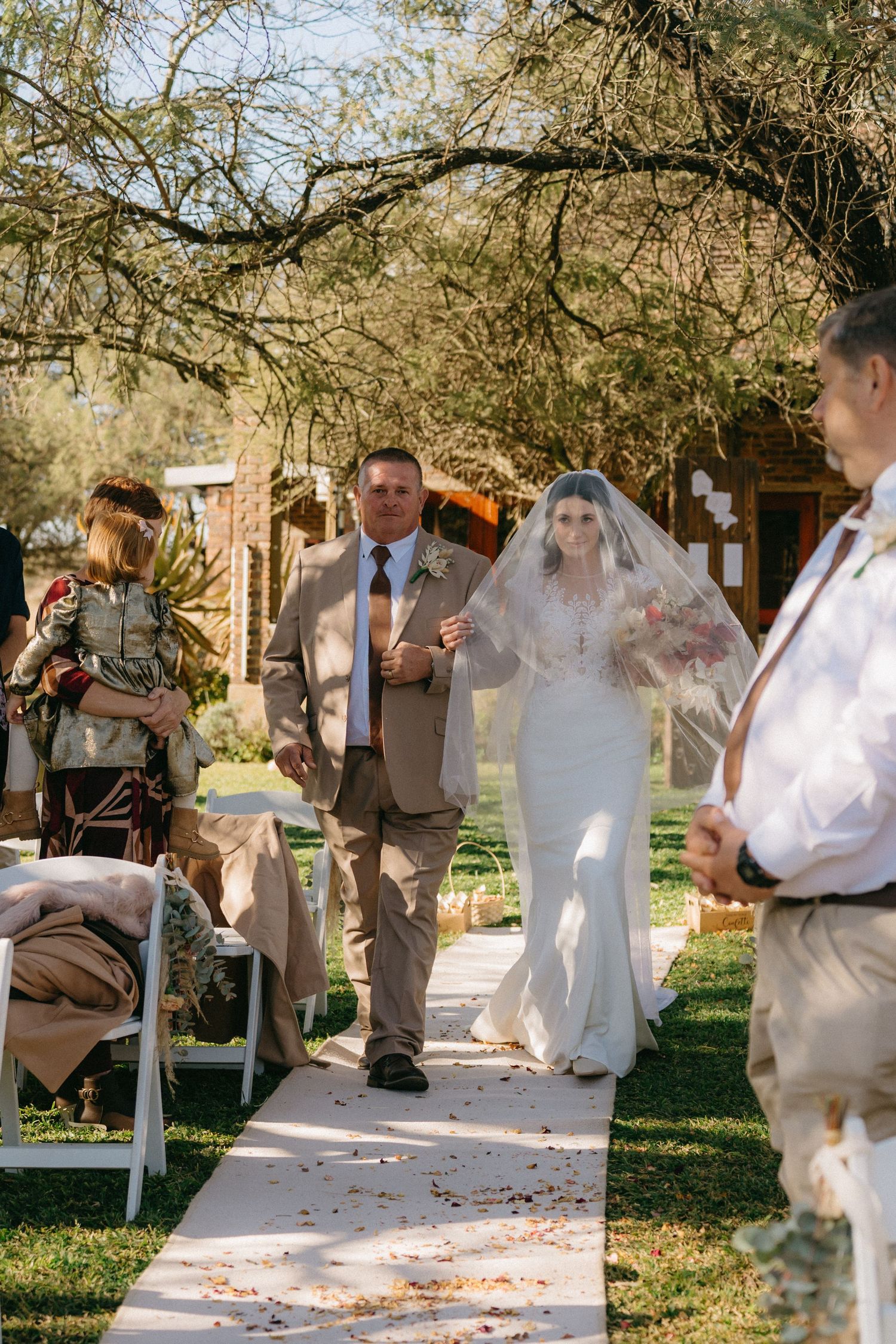 Wedding celebration sequence showing joyful moments under trees with white decor.