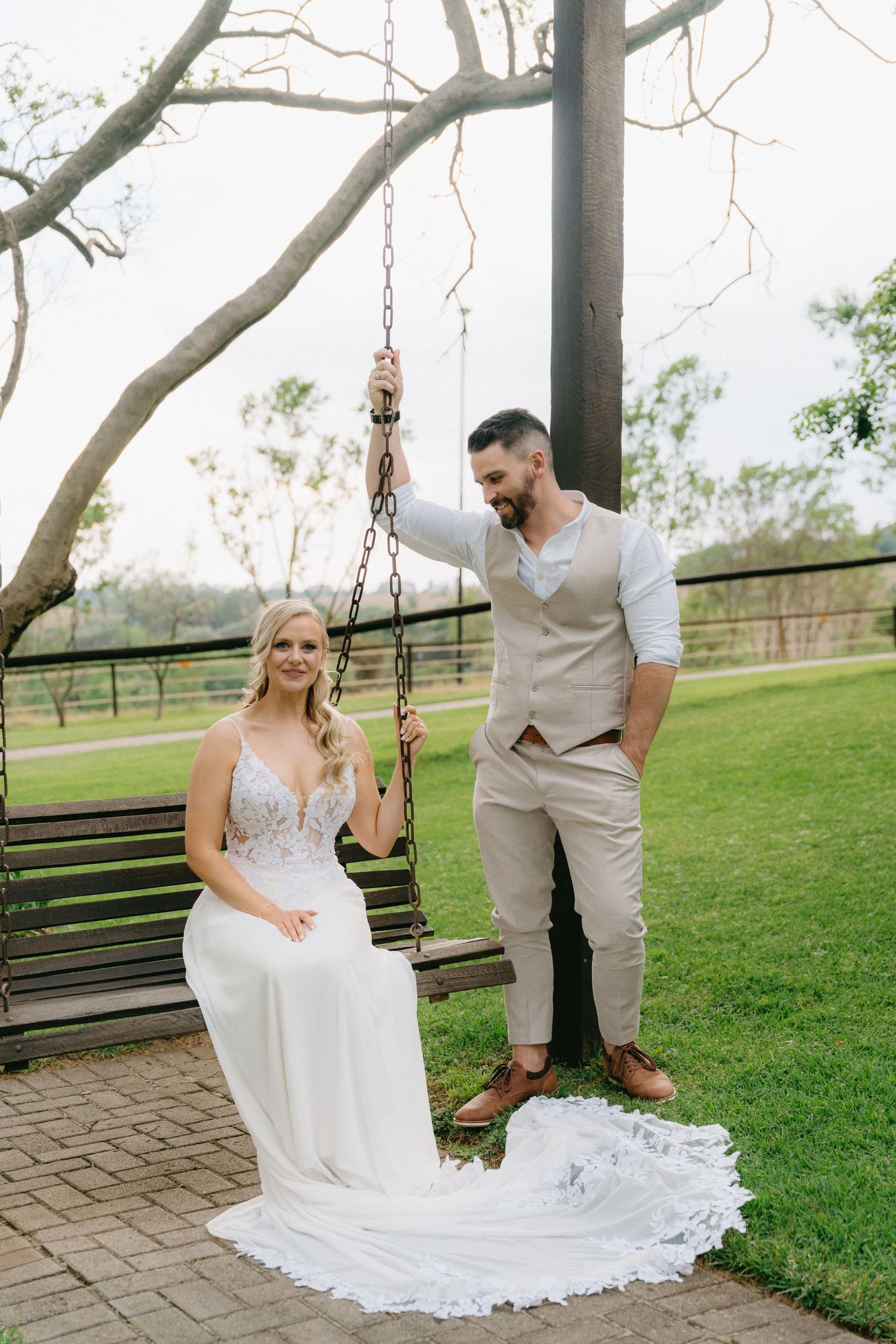 Romantic moments shared on a wooden porch swing surrounded by greenery.