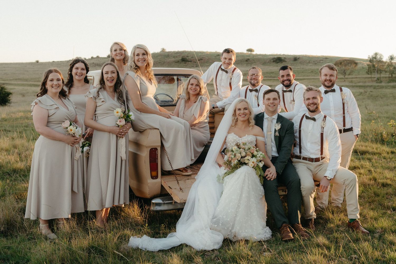 Wedding party posing on vintage truck tailgate in scenic Free State setting