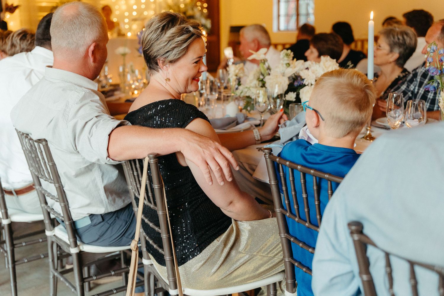 Guests seated at long tables during a casual restaurant gathering with warm lighting and rustic decor.