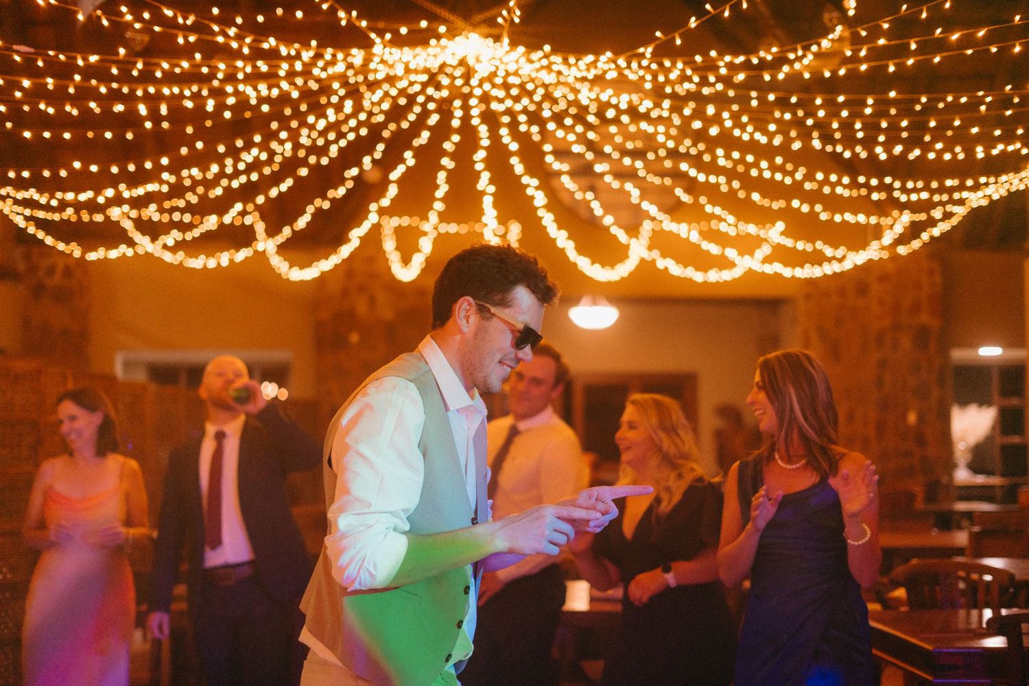 Wedding reception venue decorated with stunning canopy of twinkling string lights creating a magical atmosphere.