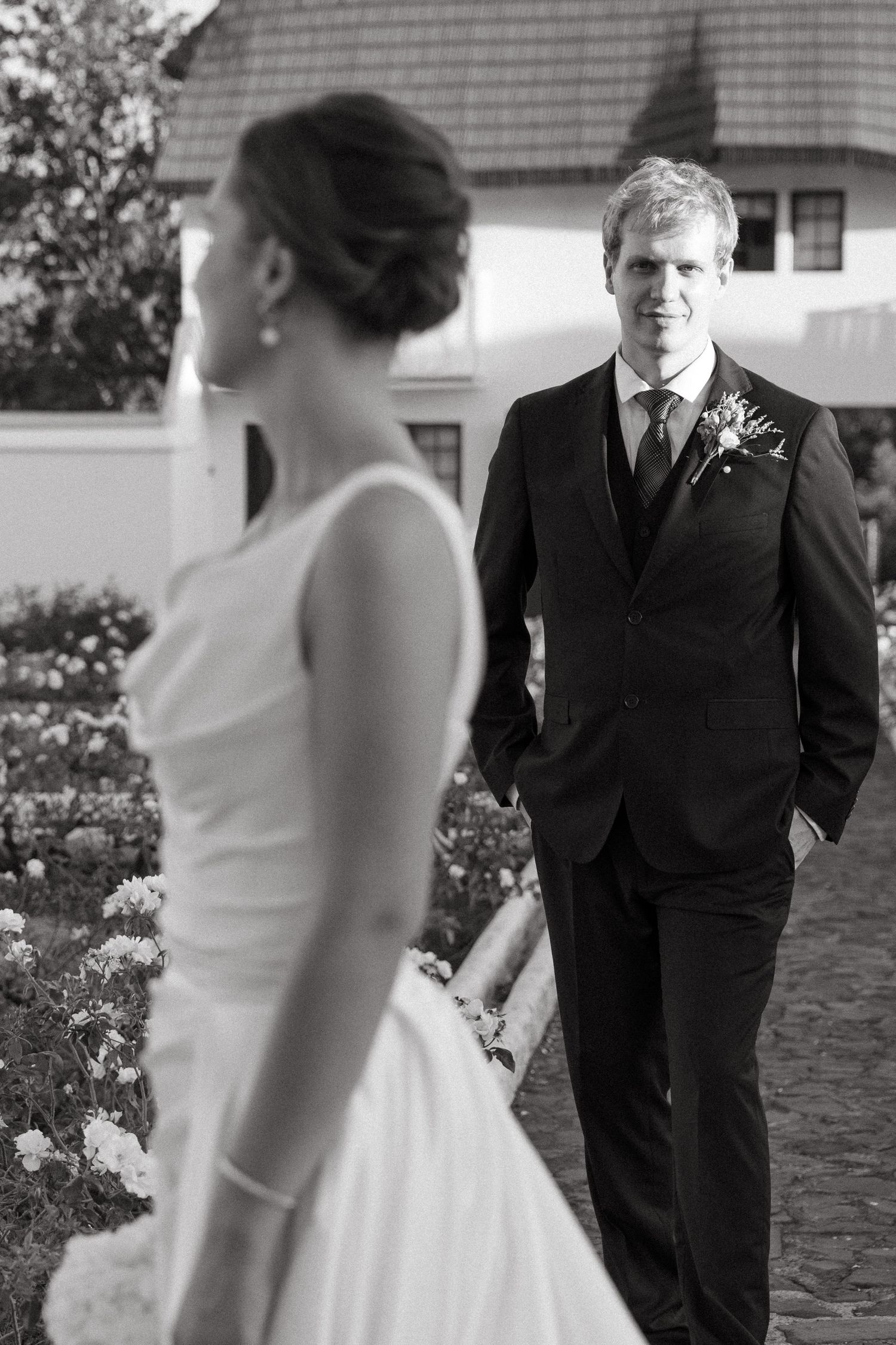 Black and white wedding photo sequence showing a romantic first look moment between bride and groom outdoors.