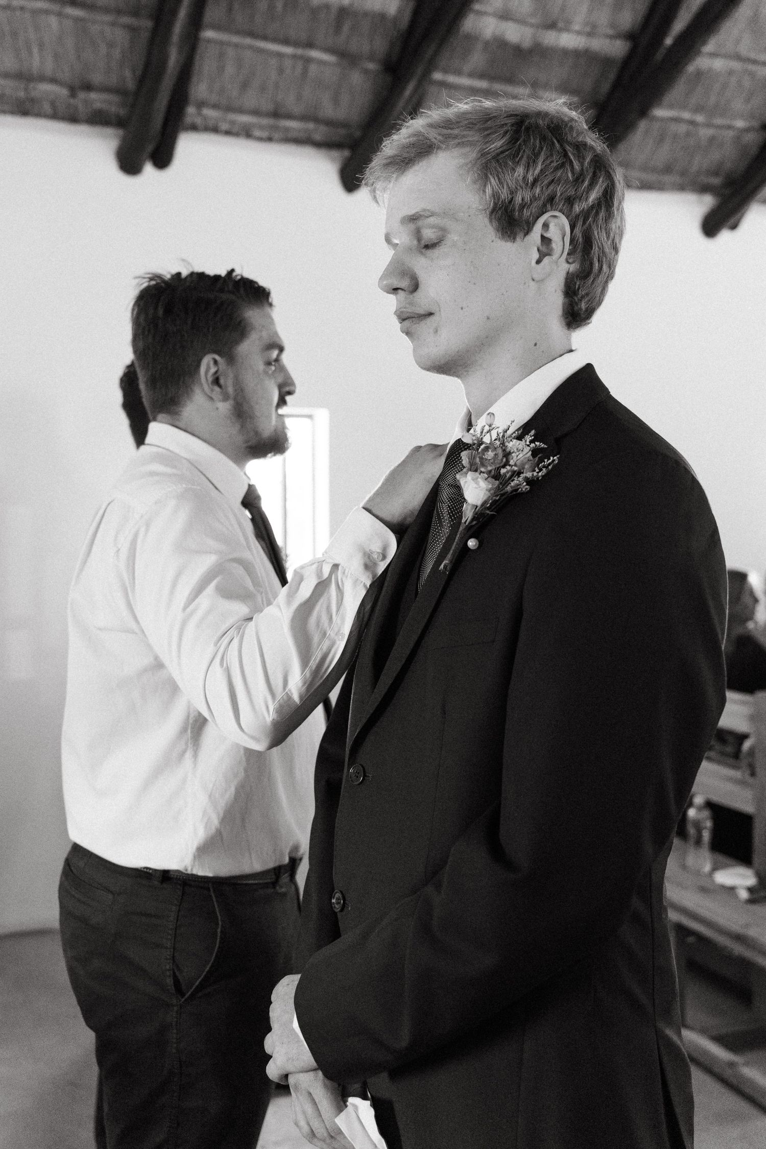 Two people in formal attire share an intimate moment in a black and white photo series.