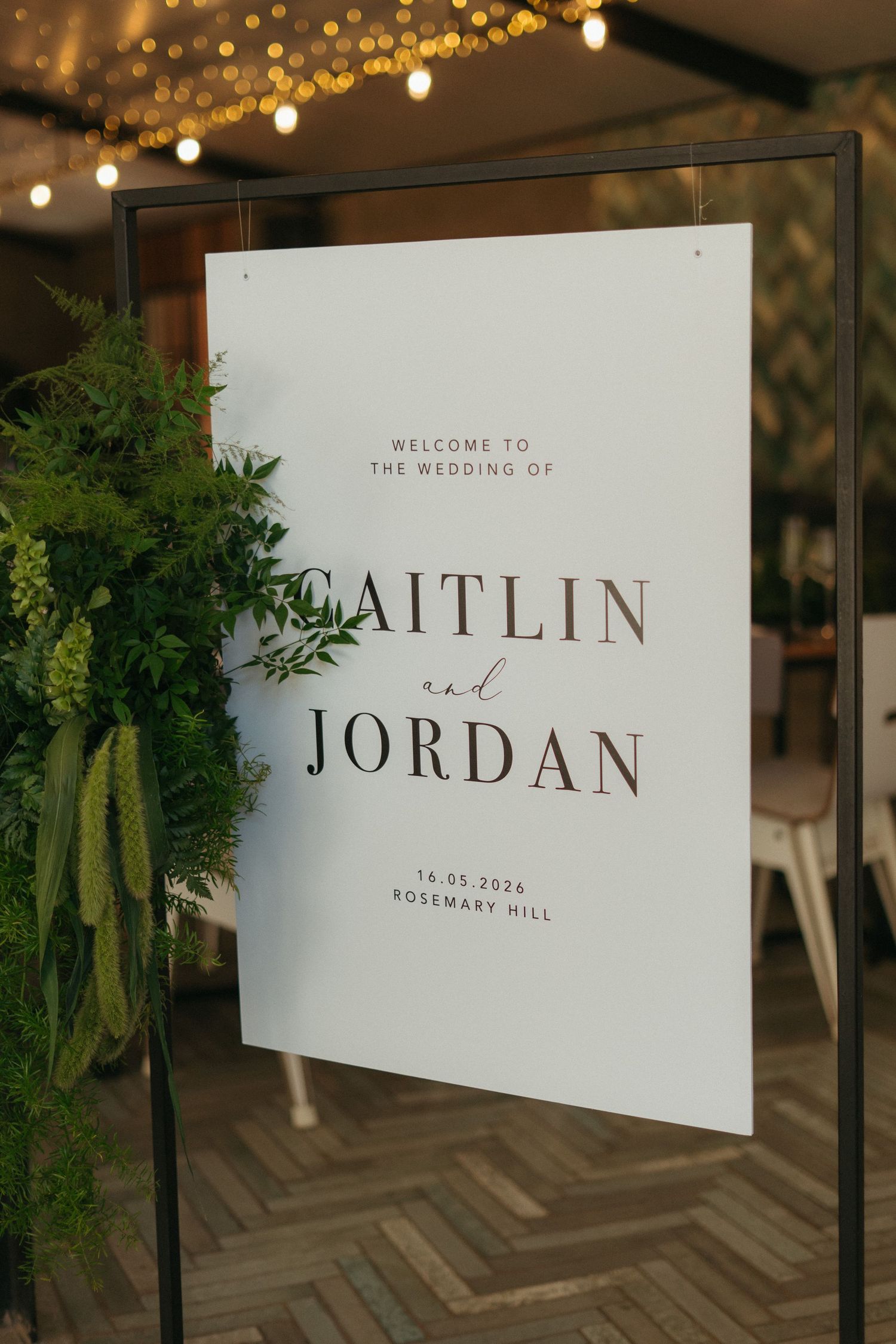 Elegant wedding welcome sign for Caitlin and Jordan at Rosemary Hill, dated 16.03.2026, adorned with lush greenery.