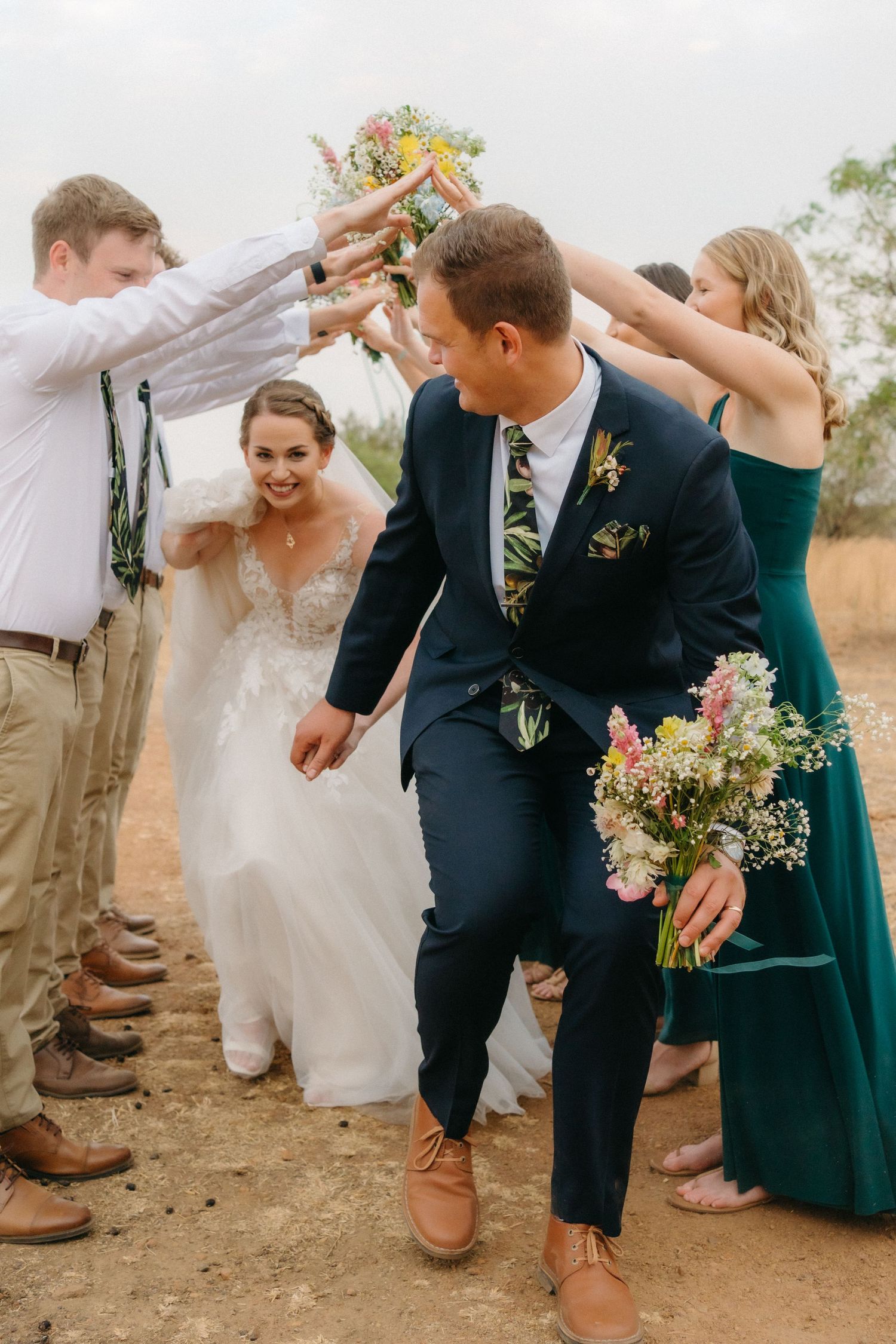 Wedding party creates celebratory arch tunnel for newlyweds to walk through.