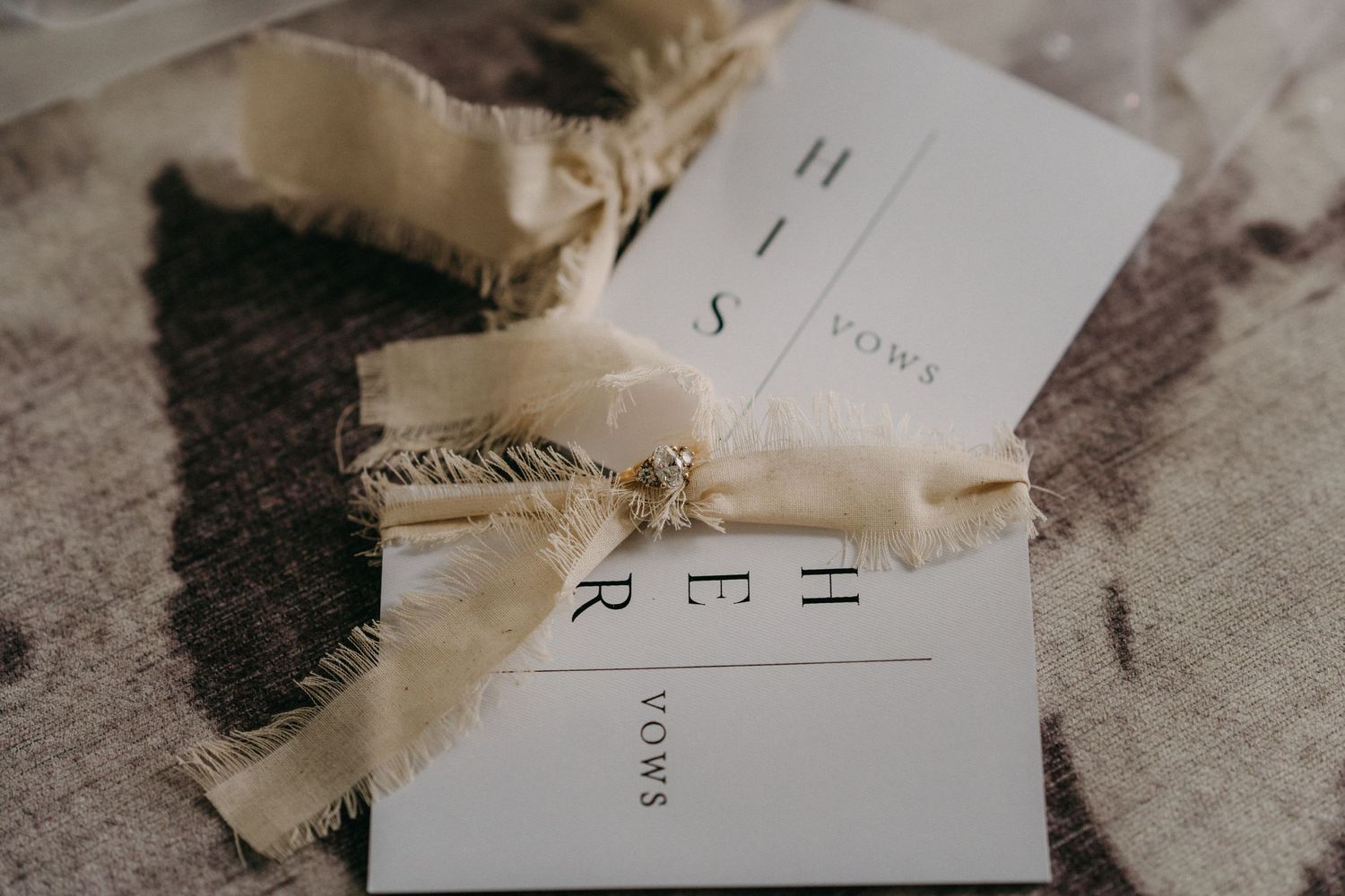 Wedding invitation cards tied with delicate twine ribbon against a light textured background.