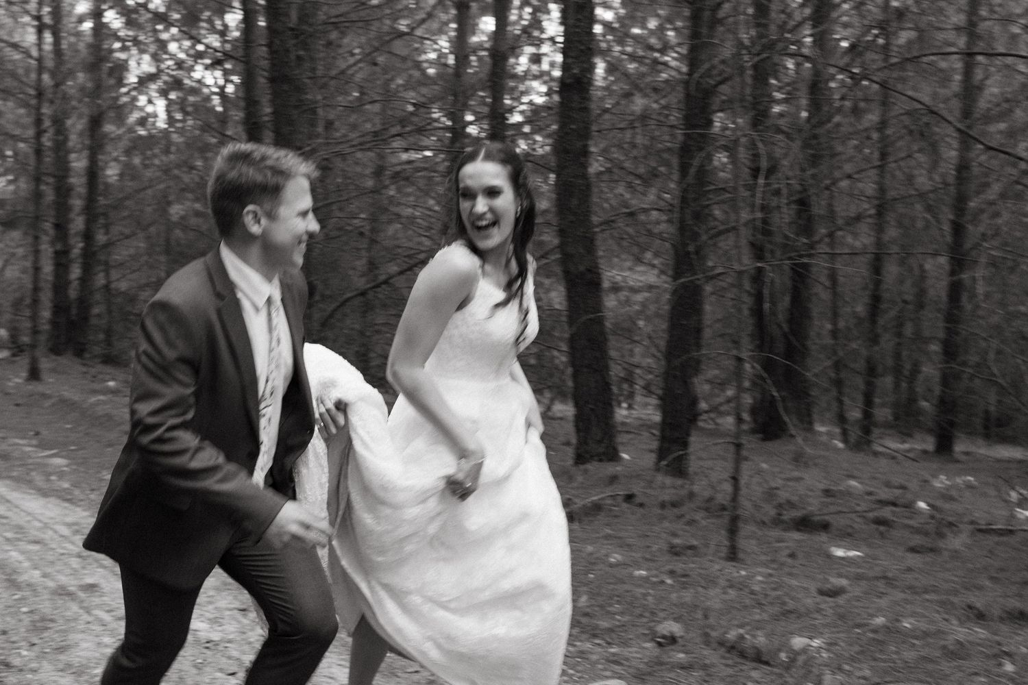 Black and white wedding photos showing couple walking through forest setting in formal attire.