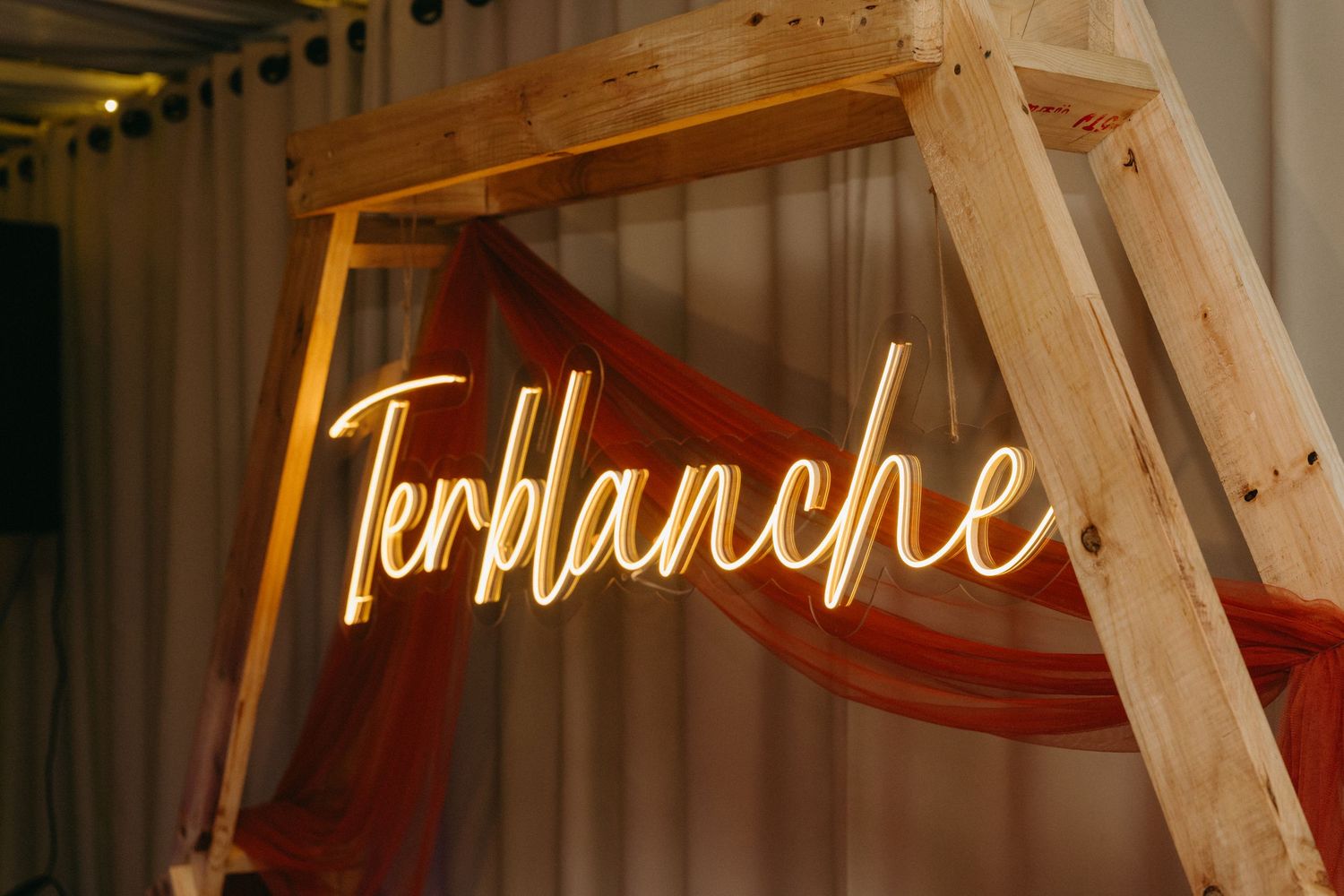 Illuminated neon signage creating a warm glow in a rustic wooden venue setting.