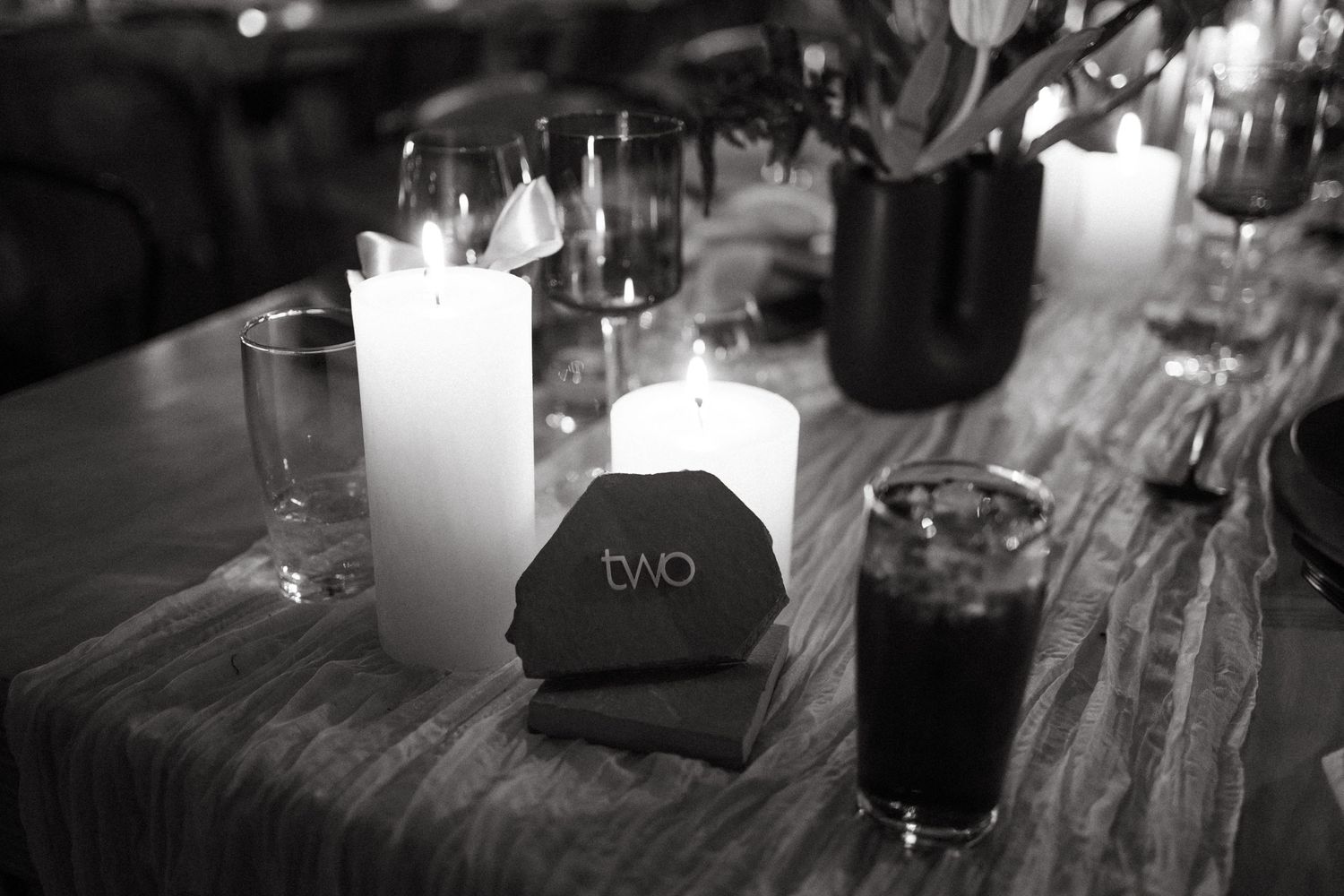 Black and white table setting with candles and wedding decor at an elegant reception.