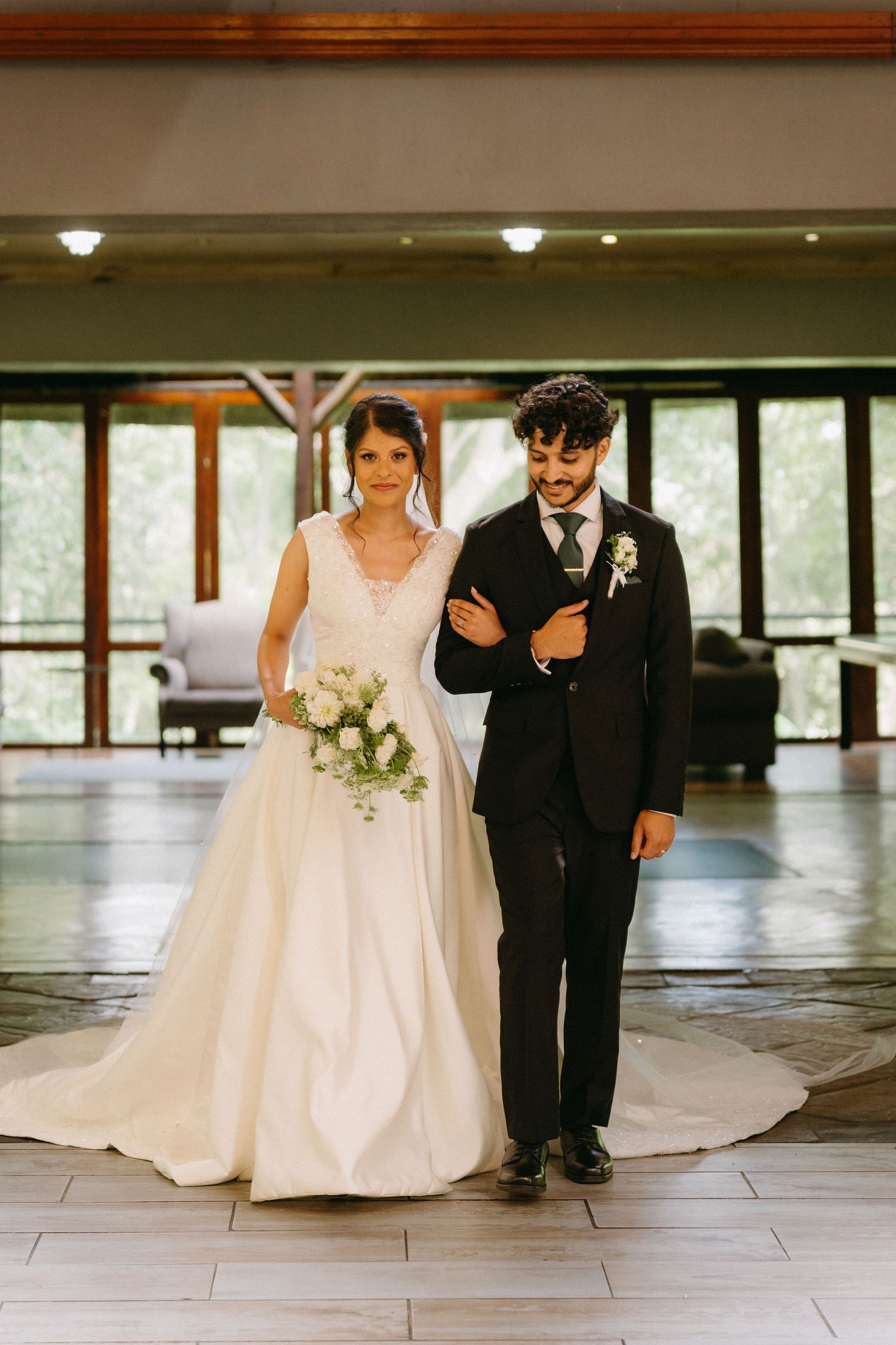Elegant indoor wedding photos showing couple in classic formal attire against modern venue backdrop.