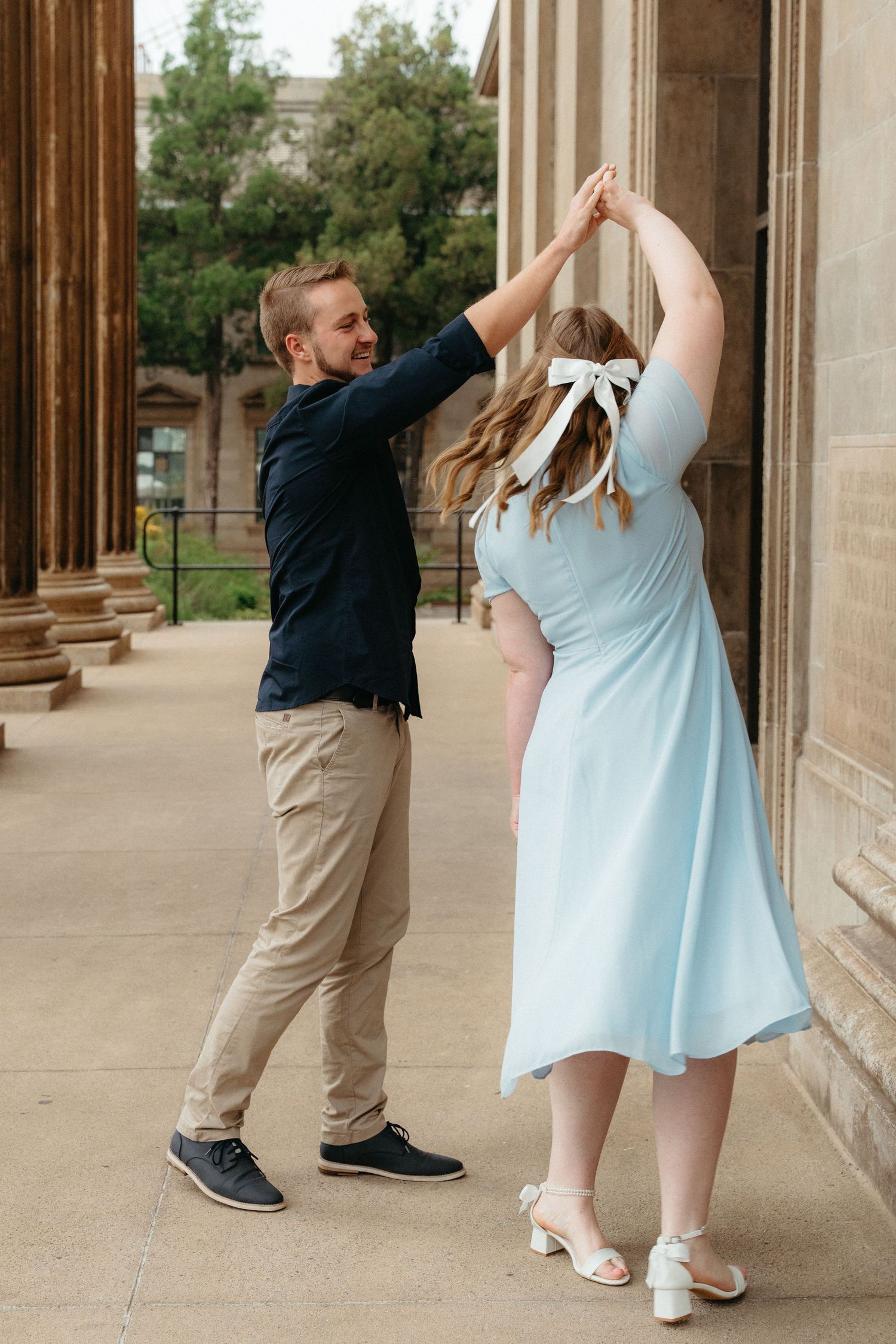 A couple in formal attire dances together in an elegant columned hallway on the Wits Campus in Johannesburg