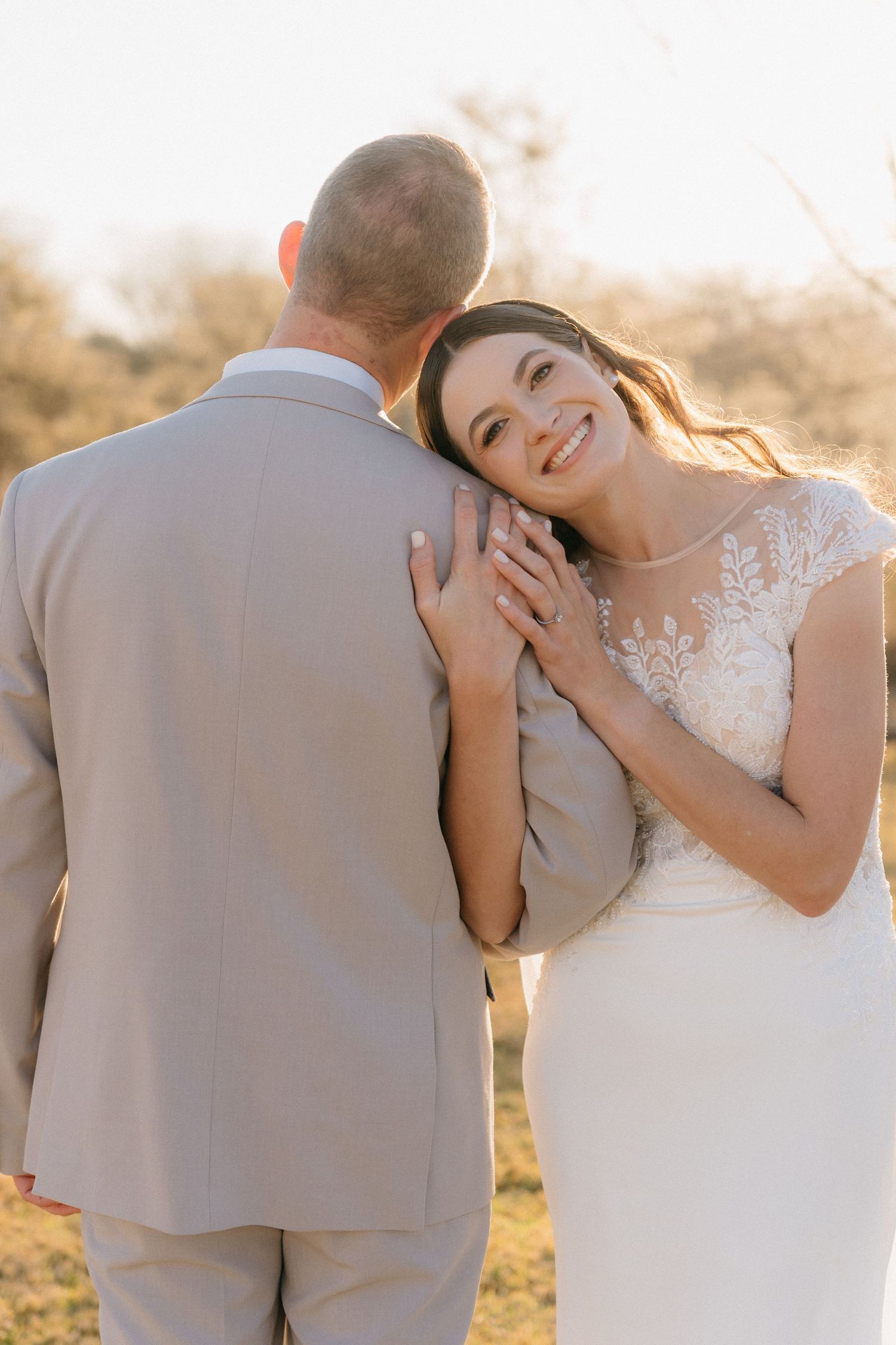 Intimate wedding couple portraits captured in soft golden light against natural backdrop.
