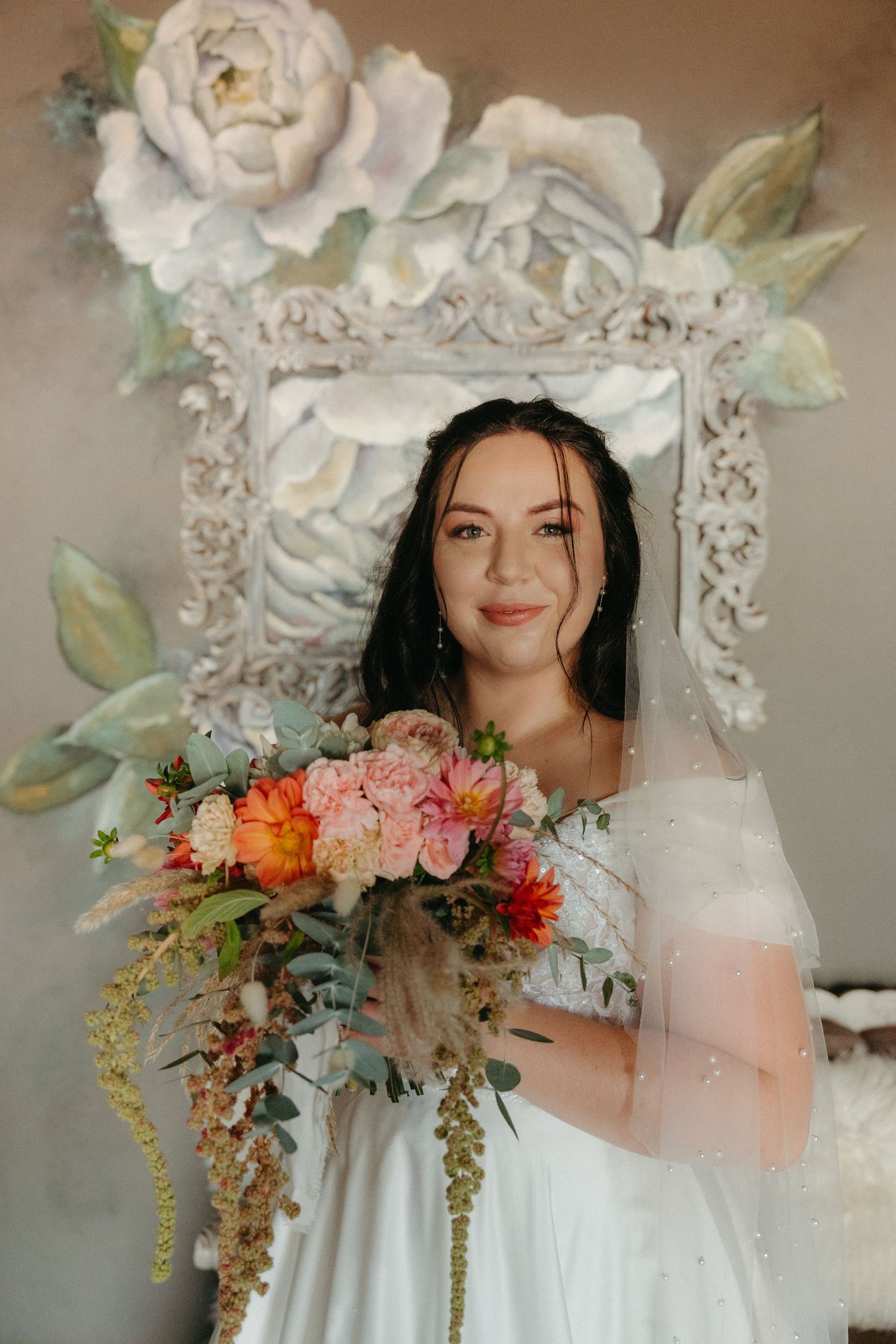 A bridal portrait with ornate floral frame and colorful bouquet.