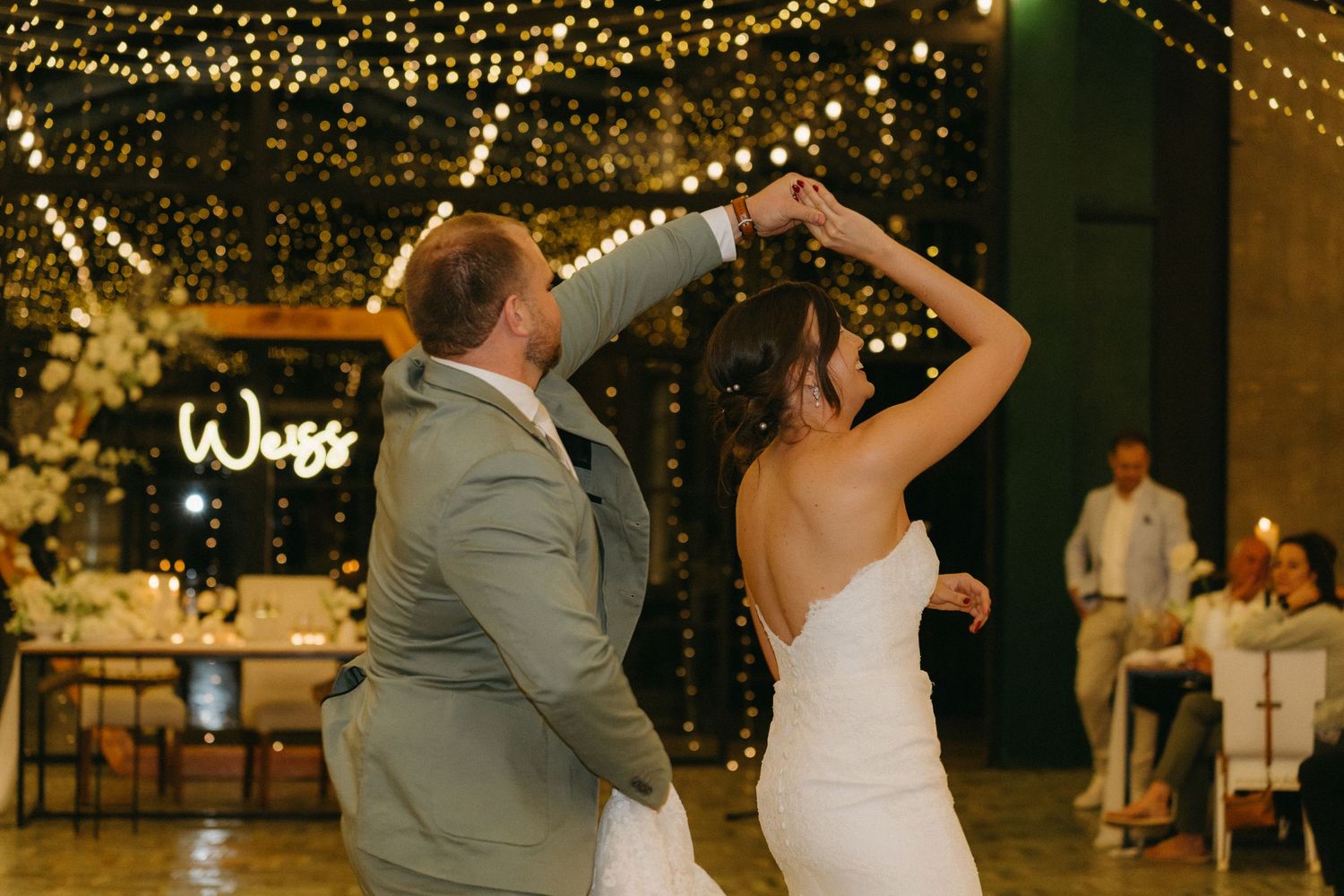 A couple shares their first dance under magical twinkle lights at their wedding reception.