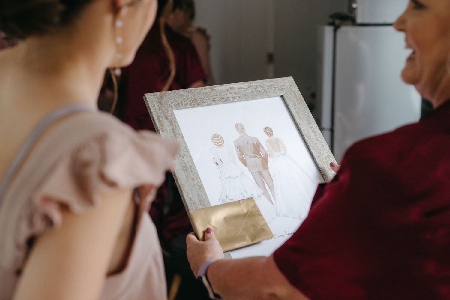 People looking at a framed photo during a wedding celebration.
