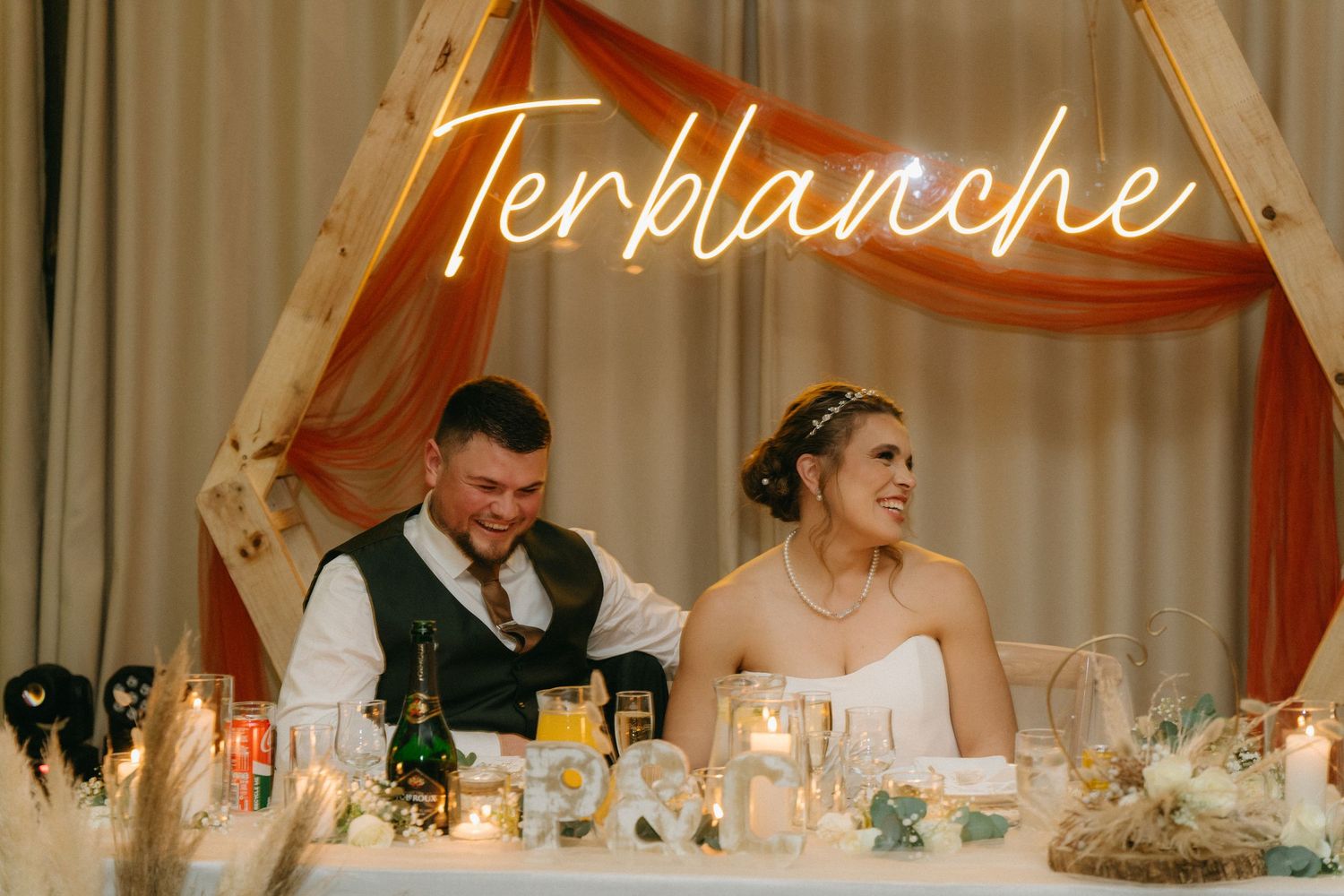 Elegant wedding reception venue with illuminated signage and decorative lighting.
