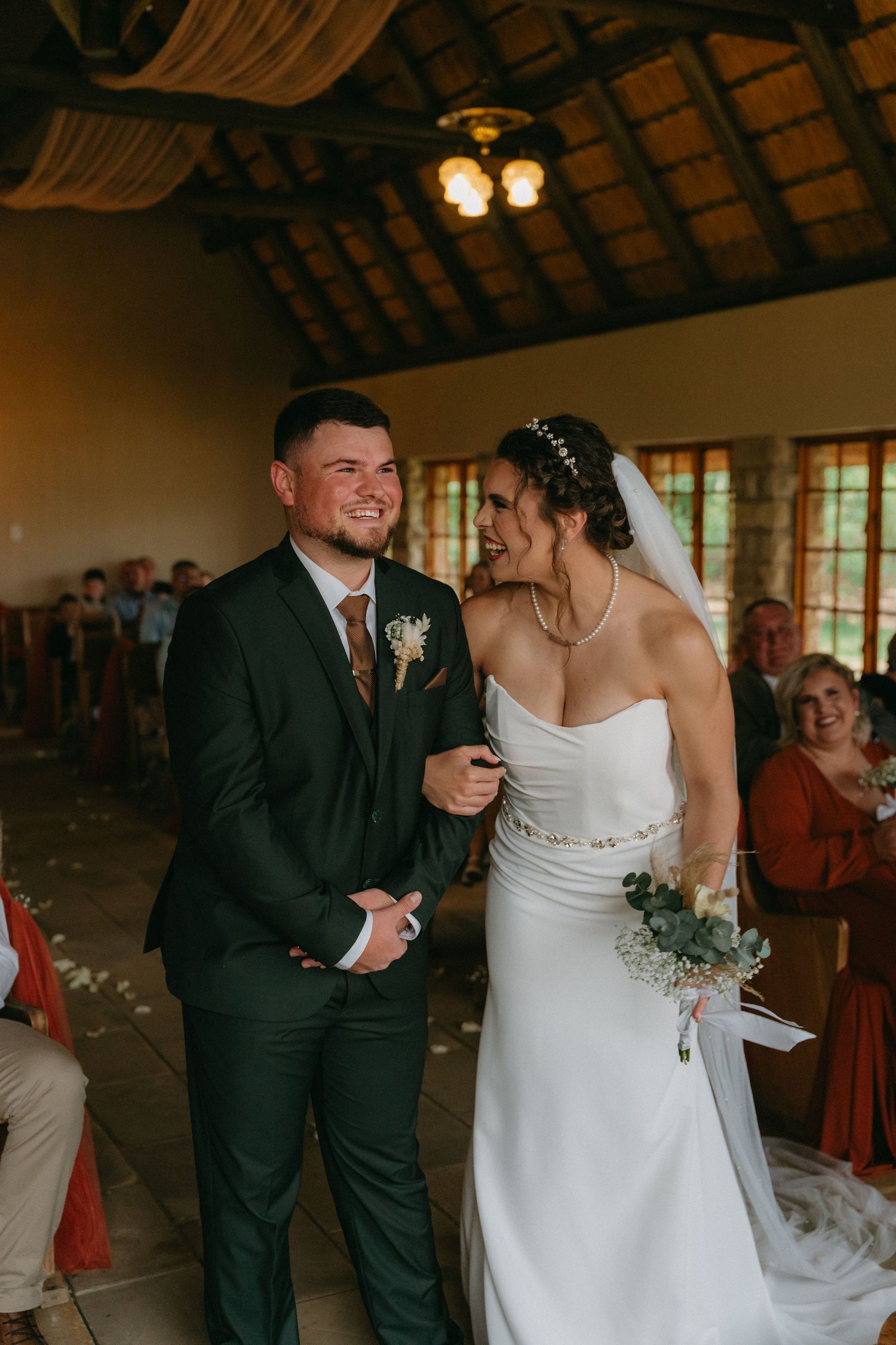 Newlyweds share intimate moments during their wedding reception in a rustic venue.