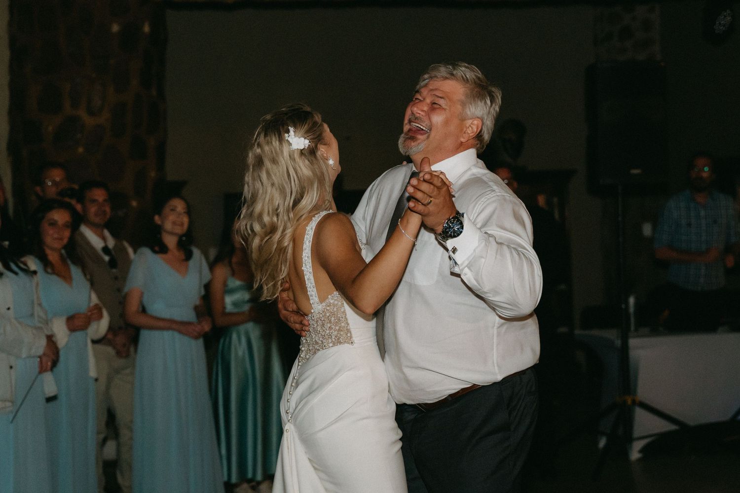 A tender dance moment captured during an evening wedding reception indoors.
