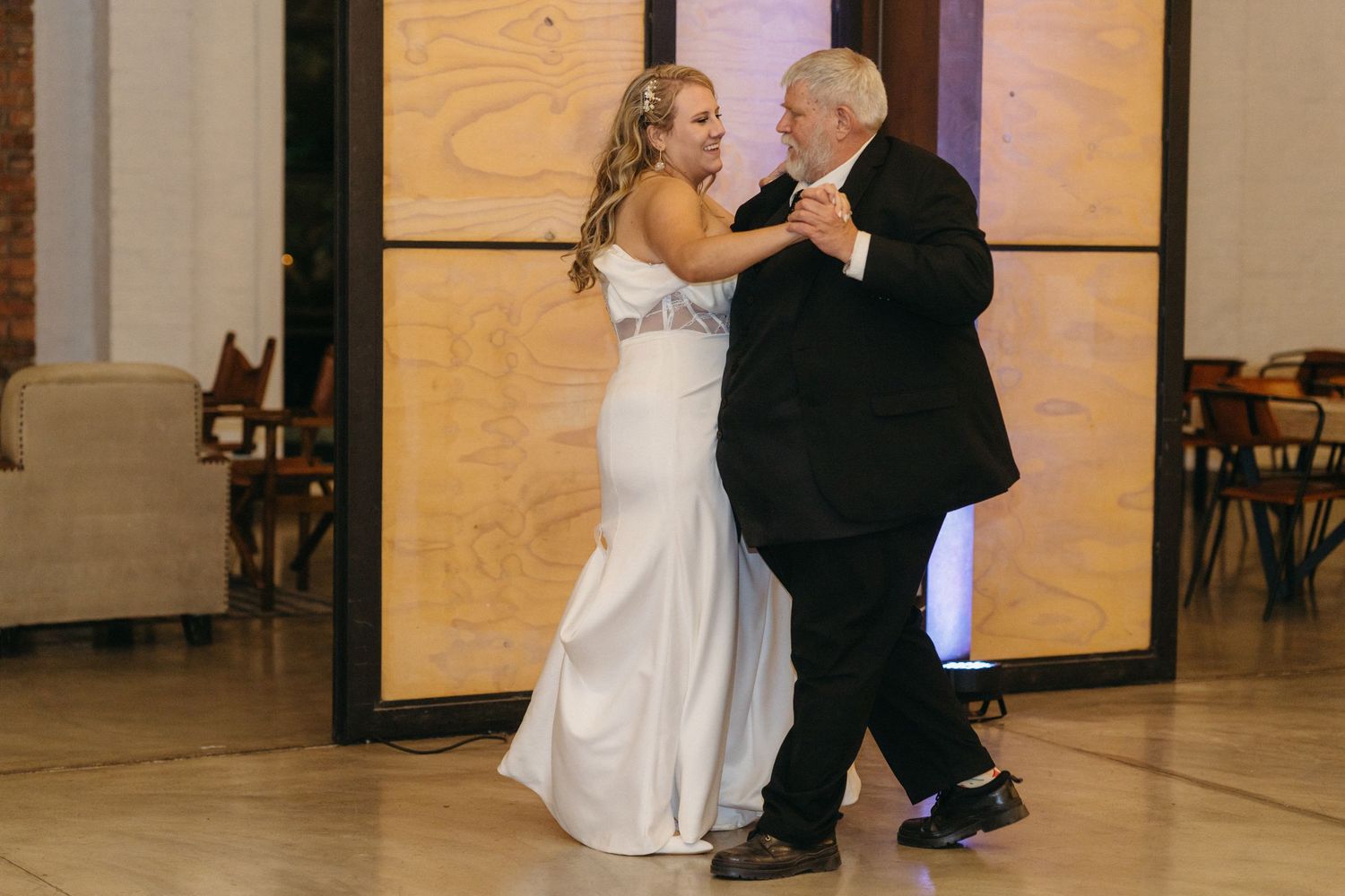 Bride and companion share special dance moment on elegant venue's dance floor.