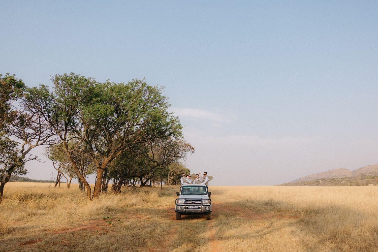 A panoramic series of rural landscape photos showing dry grasslands and scattered trees against a hazy sky.