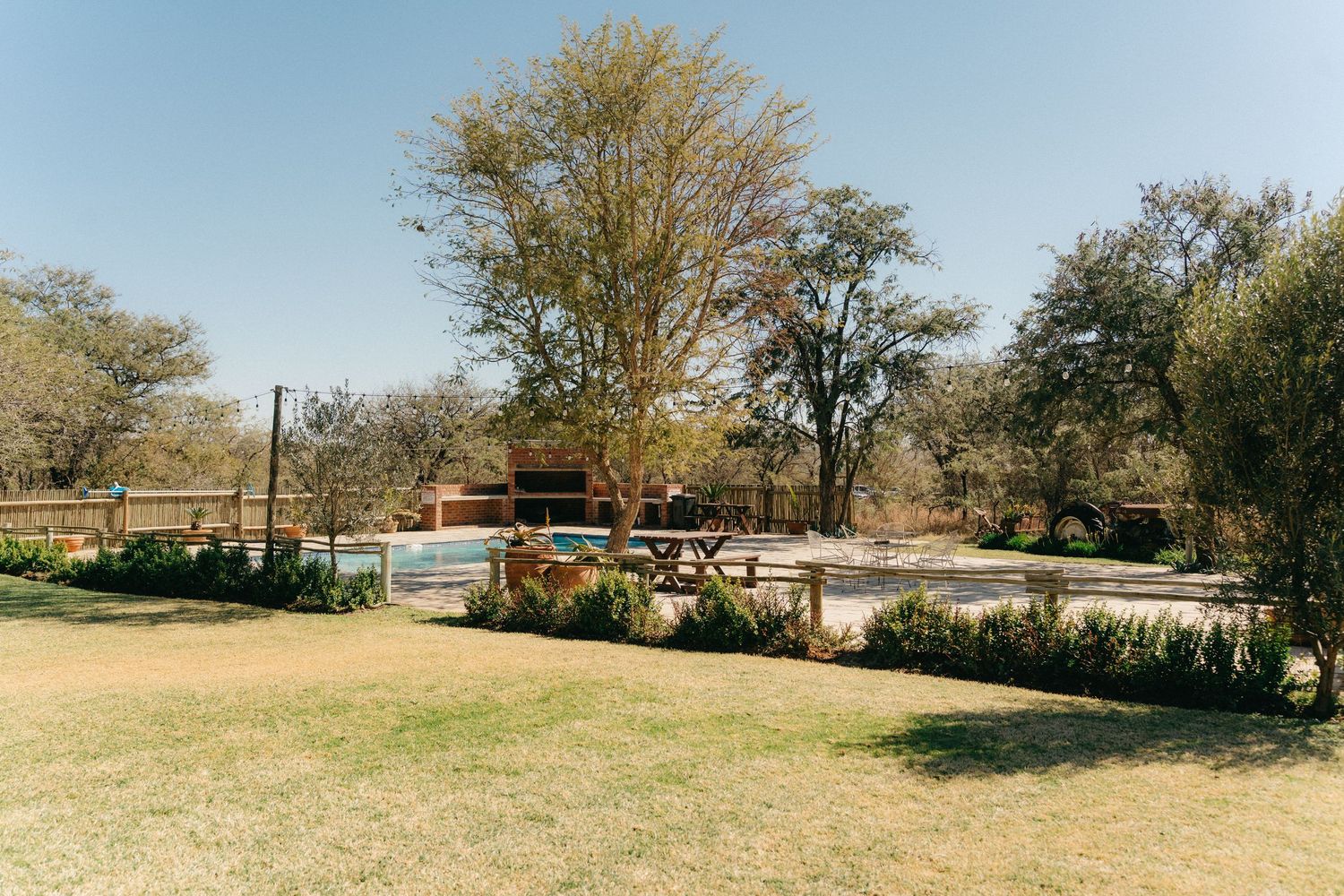 Panoramic view of a rustic outdoor wedding venue with trees and wooden structures in a natural setting.