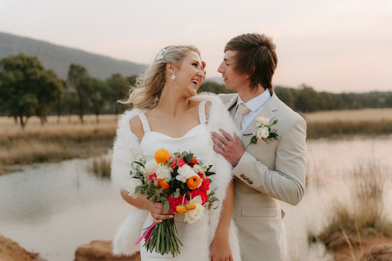 A couple shares a romantic moment in a rustic outdoor setting during golden hour.