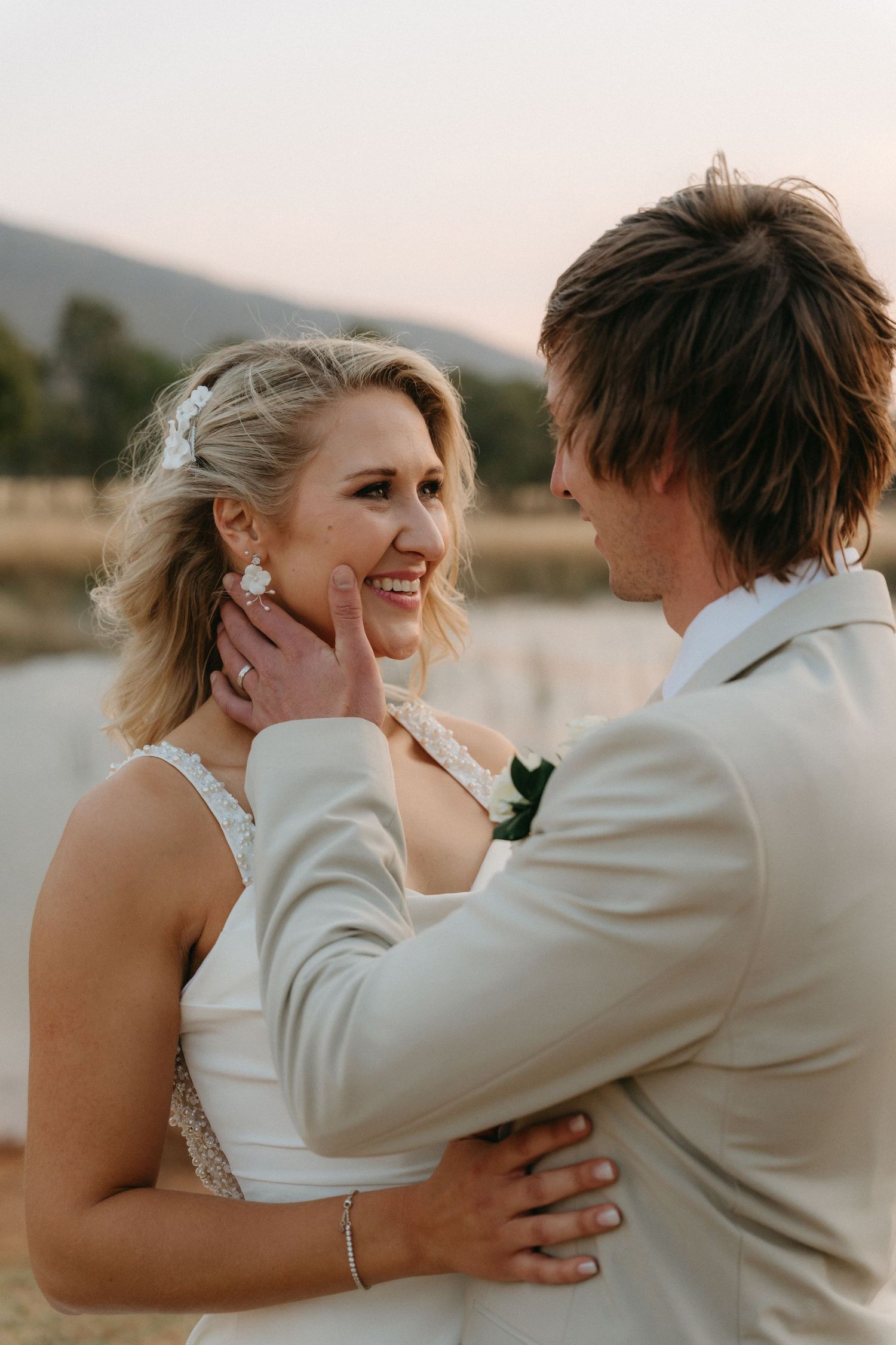 Intimate wedding portrait of a couple sharing a tender moment at sunset.