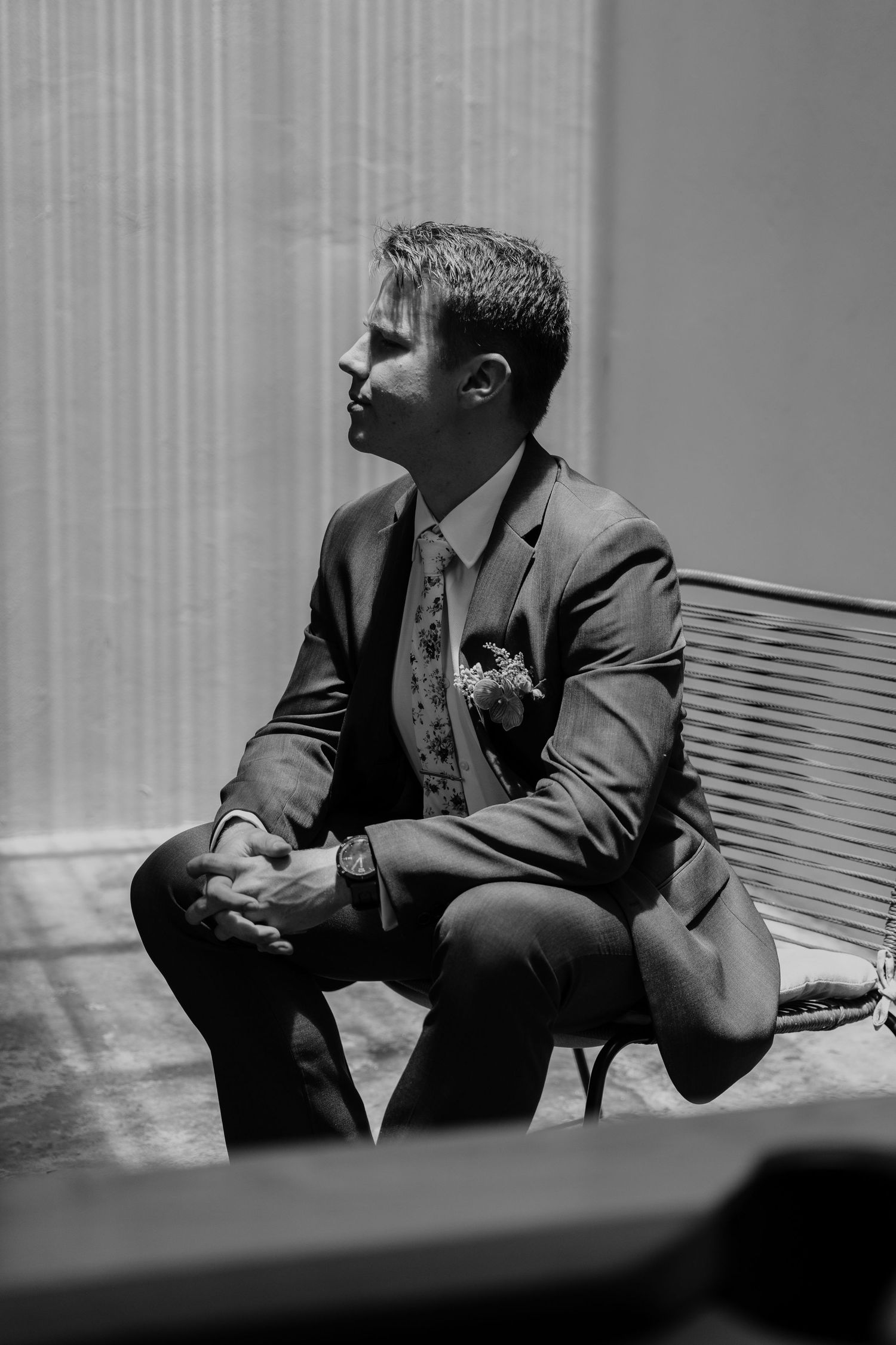 A sequence of black and white photos showing a person in a suit sitting on a bench in contemplative poses.